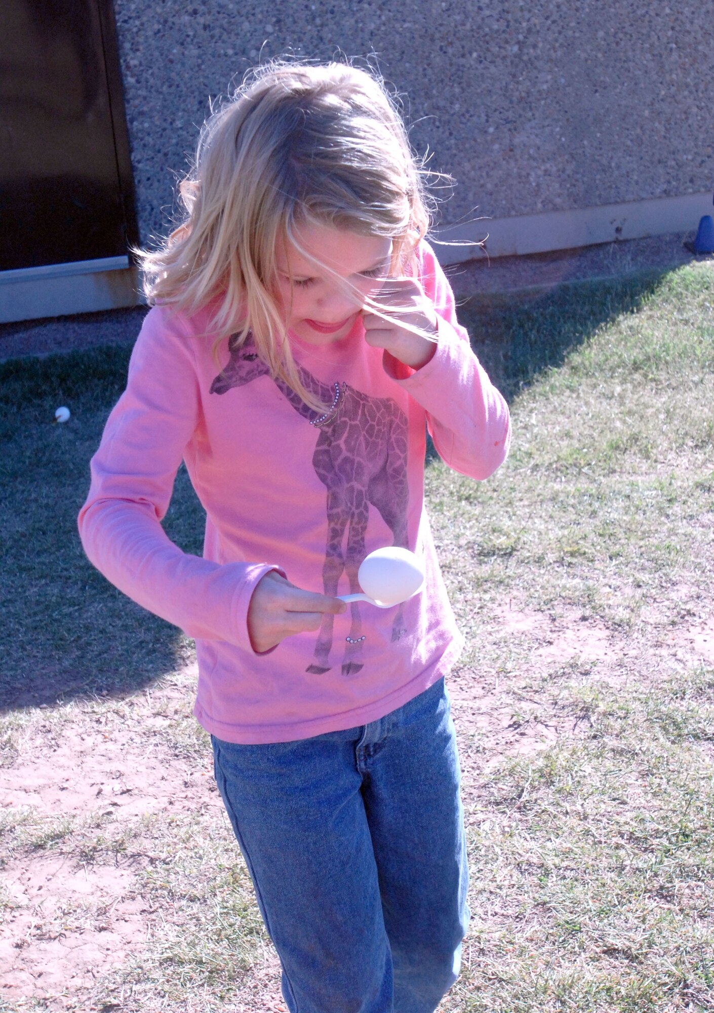 GOODFELLOW AIR FORCE BASE, Texas - Clarissa Lowry, 7, races to the finish line while trying to not drop her egg during the Kids Fall Festival at the School Age Center Nov. 4. Military youths from the Youth Center and School Age organized and ran all the games held at this year's event. (U.S. Air Force photo/Connie Hempel)