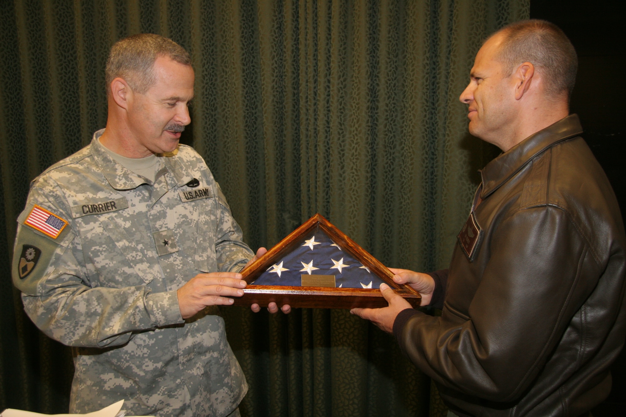 Brig. Gen. Donald Currier (left), 49th Military Police Brigade commander, 
presents Col. James Vechery (right), 60th Air Mobility Wing commander, Nov. 6 
with a token of appreciation for outstanding support from Team Travis for the 
49th MP brigade's homecoming. The Army unit of nearly 100 Soldiers returned 
Aug. 10 after a one-year deployment to train the Iraqi police. California Gov. 
Arnold Schwarzenegger joined Team Travis to welcome home the Soldiers. Team 
Travis worked for several weeks with the California National Guard to ensure 
the welcome home reception allowed for more than 400 family members to greet 
their returning Soldiers as they exited the plane at Travis Air Force Base.
