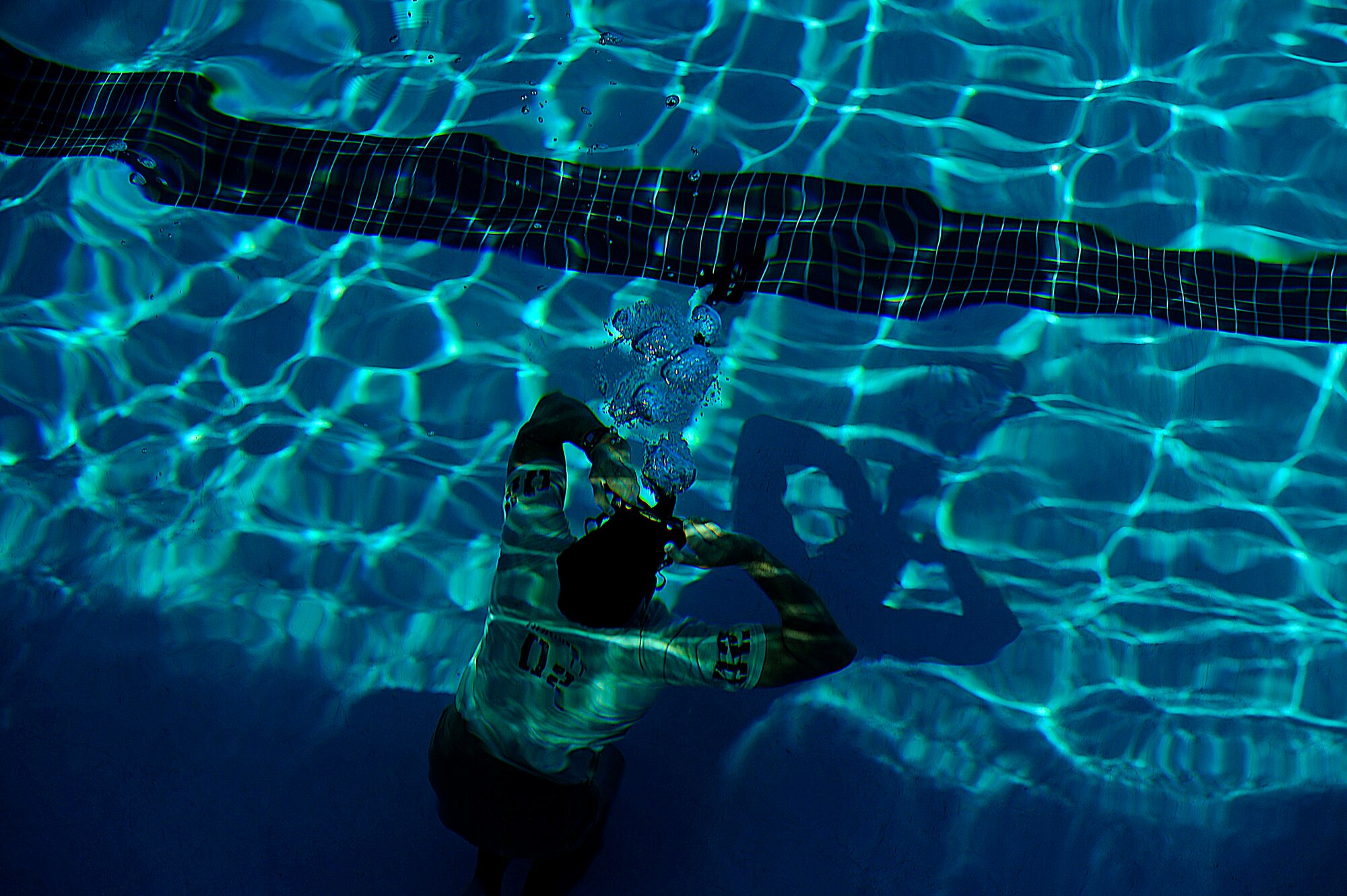 A U.S. Air Force member from the Special Tactics Training Squadron, Air Force Special Operations Command, Hurlburt Field, Fla., clears his mask from the bottom of the pool during pre-scuba training Sept. 21, 2010. (U.S. Air Force Photo by Master Sgt. Russell E Cooley IV/Released)