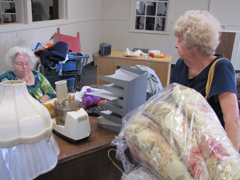 Mary Clemons, manager of the Gunter Thrift Shop, accepts and logs Hazel Pierce's donated items. (Air Force photo by Airman 1st Class Christopher S. Stoltz)
