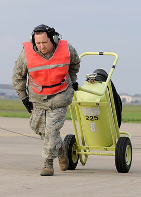 RAF MILDENHALL, England -- Staff Sgt. Ricardo Flores, 100th Aircraft Maintenance Squadron communications and navigation, moves a fire extinguisher away from a KC-135 Strotanker after a pre-flight inspection here Nov. 1, 2010.  Sergeant Flores marshalled the lead aircraft of a three-ship formation that refueled a B-52 Stratofortress.  (U.S. Air Force photo/Senior Airman Tabitha M. Lee)