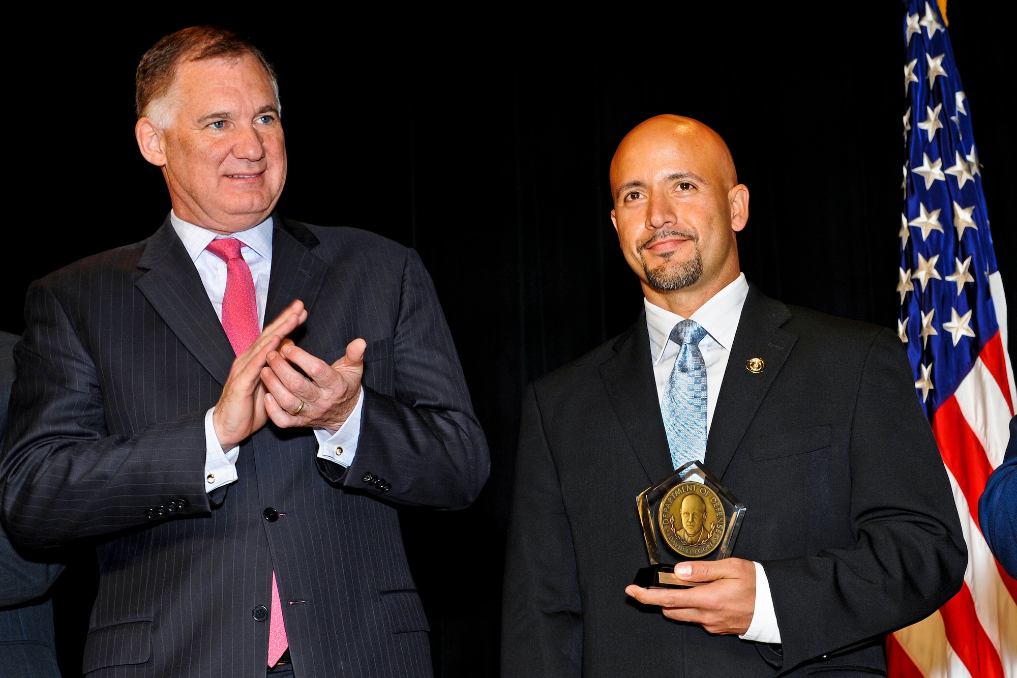 Deputy Secretary of Defense William J. Lynn III applauds Manuel A. Fajin after presenting him the Defense Department's David O. Cooke Award for Excellence in Public Administration during ceremonies at the Pentagon, Nov. 4, 2010. Mr. Fajin is a special agent with the Air Force Office of Special Investigations’ Force Protection Detachment Colombia.  (Defense Department photo/Bob Ward)