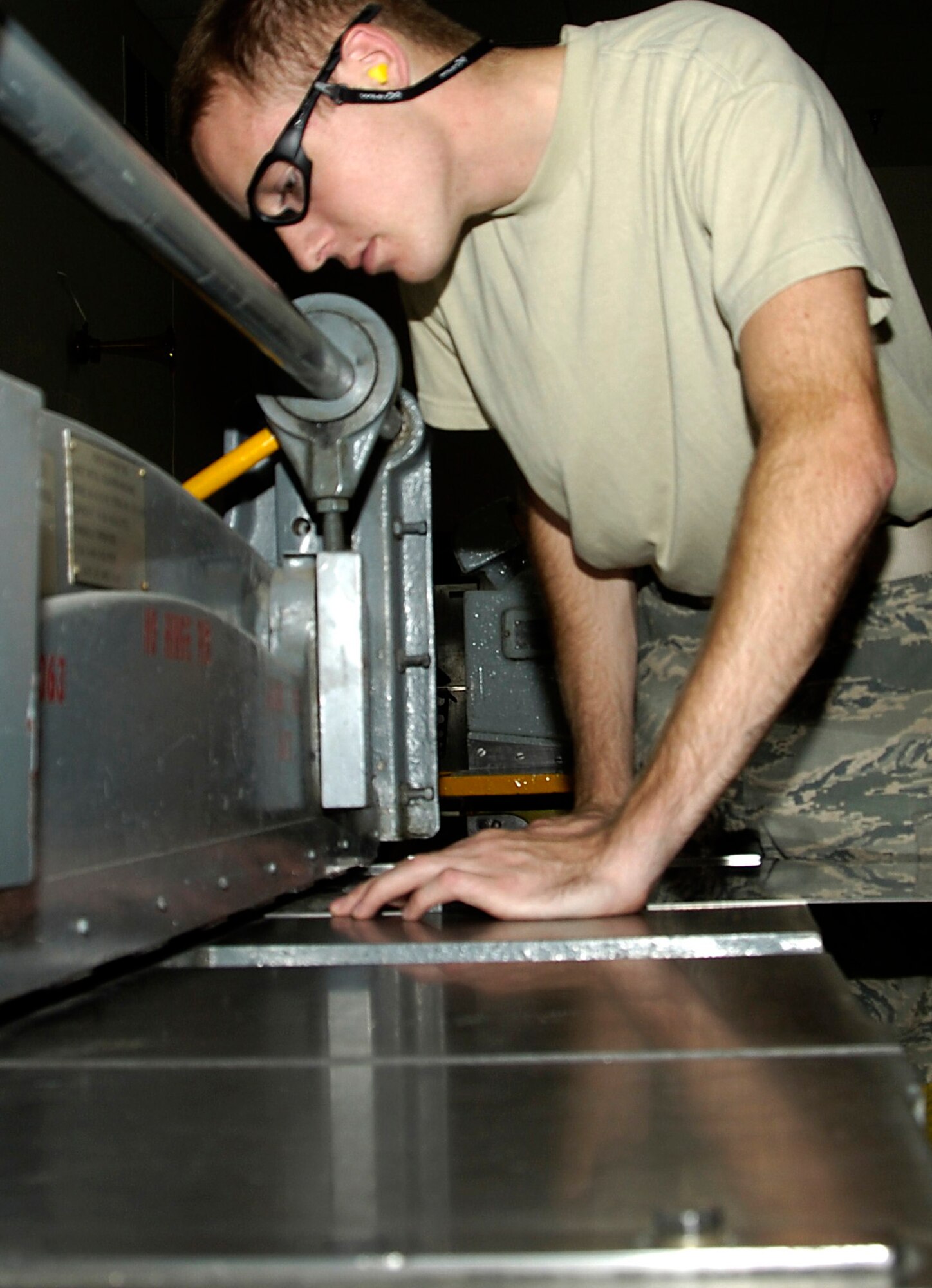 Airman Robert Hausen, aircraft structural maintainer, operates a power sheer to cut a piece of sheet metal Aug. 6, 2010. Structural maintenance airmen are trained to use metalworking equipment and tools to form, cut, bend, and fasten parts of damaged structures and components (U.S. Air Force photo/ Airman 1st Class Natasha E. Stannard)