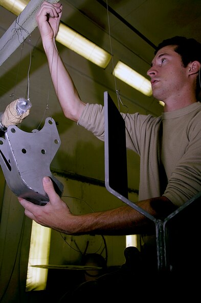Senior Airman Scott Trombley,92nd Maintenance Squadron aircraft structural maintainer, hangs bracket for priming Aug 6, 2010, at Fairchild Air Force Base, Wash. The bracketis hung so he can primer the entire piece without having to risk damaging it. (U.S. Air Force Photo/ Airman 1st Class Natasha E. Stannard) 

