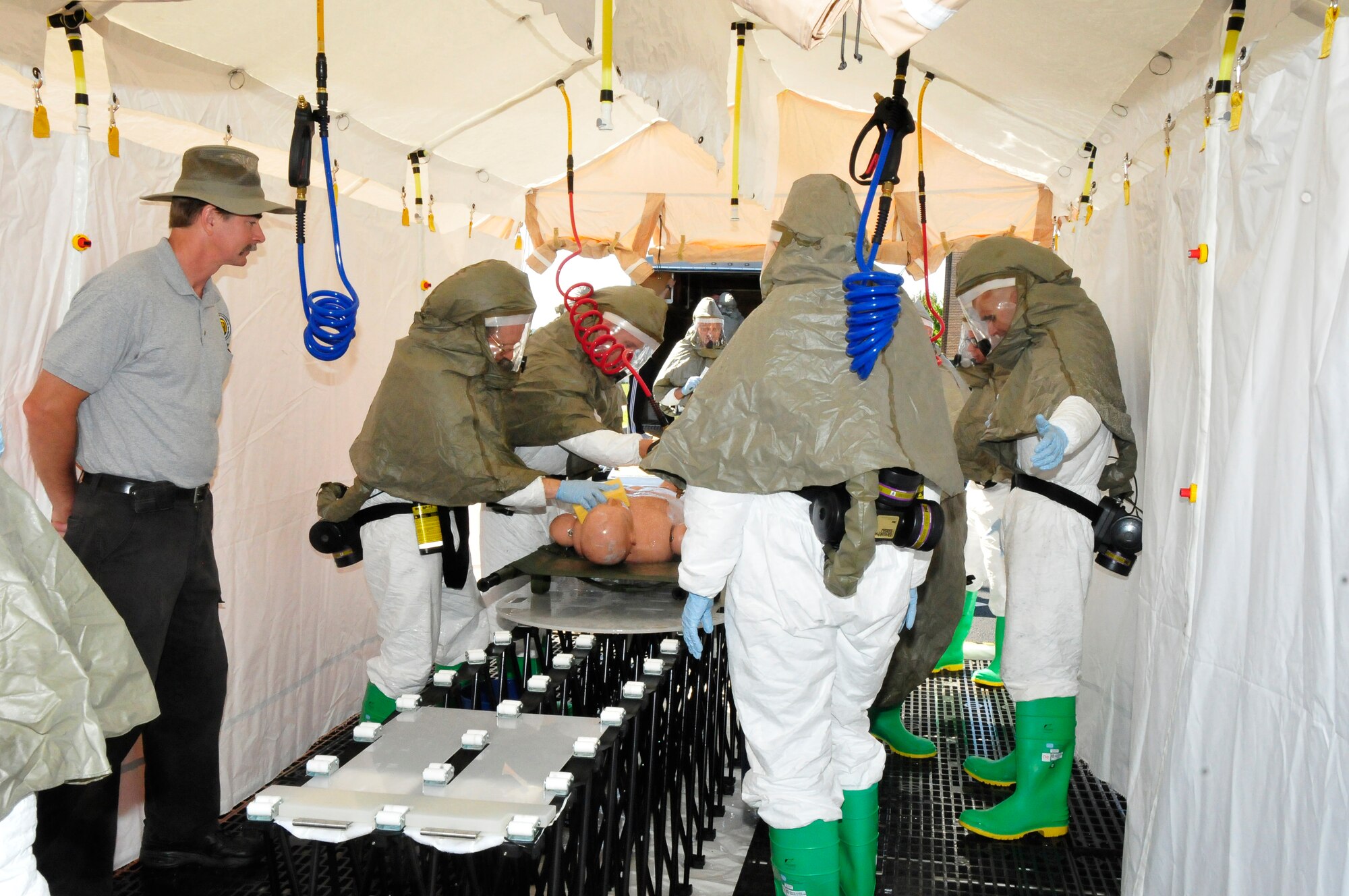 Instructor Tom Bocek, training manager for the In-Place Patient Decontamination (IPPD) unit, looks on as members of the 134 ARW demonstrate how to decontaminate a patient.  The decontamination training was held to better prepare the Air National Guard members in case of a real world incident that may require decontamination of medically injured individuals.  The 134 ARW was the first Air National Guard base to recieve this specific training.  (US Air Force photo by Tech. Sgt. Kendra Owenby, 134 ARW Public Affairs/Released by Capt Gary Taft, 134 ARW PAO)