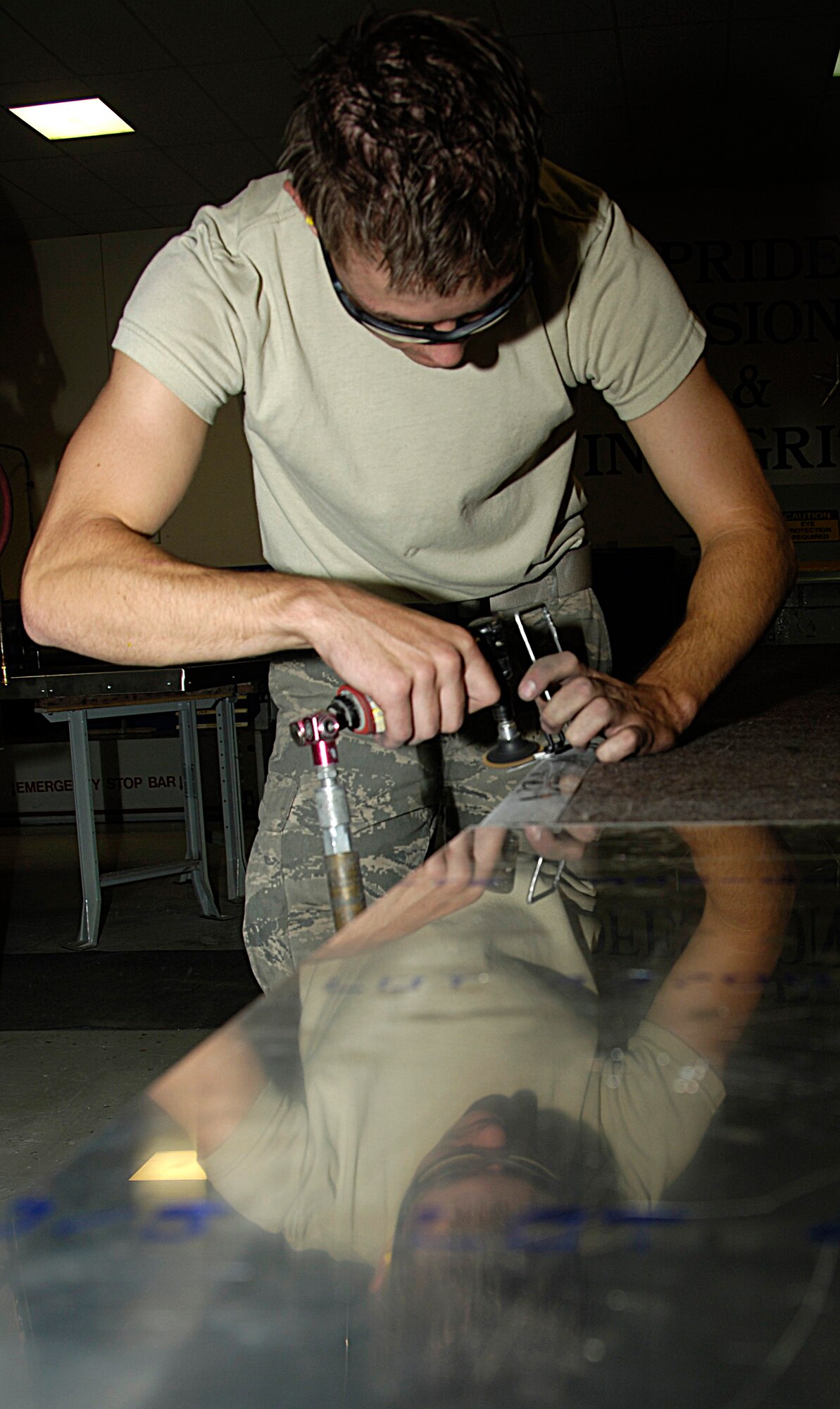 Airman 1st Class Easton Rentmeister, aircraft structural maintainer, smooths the edges of a piece of sheet metal with a sander Aug. 6, 2010. Aircraft structural maintainers maintain the structural integrity of aircraft by assembling and reparing structural parts and components.  (U.S. Air Force photo/ Airman 1st Class Natasha E. Stannard)