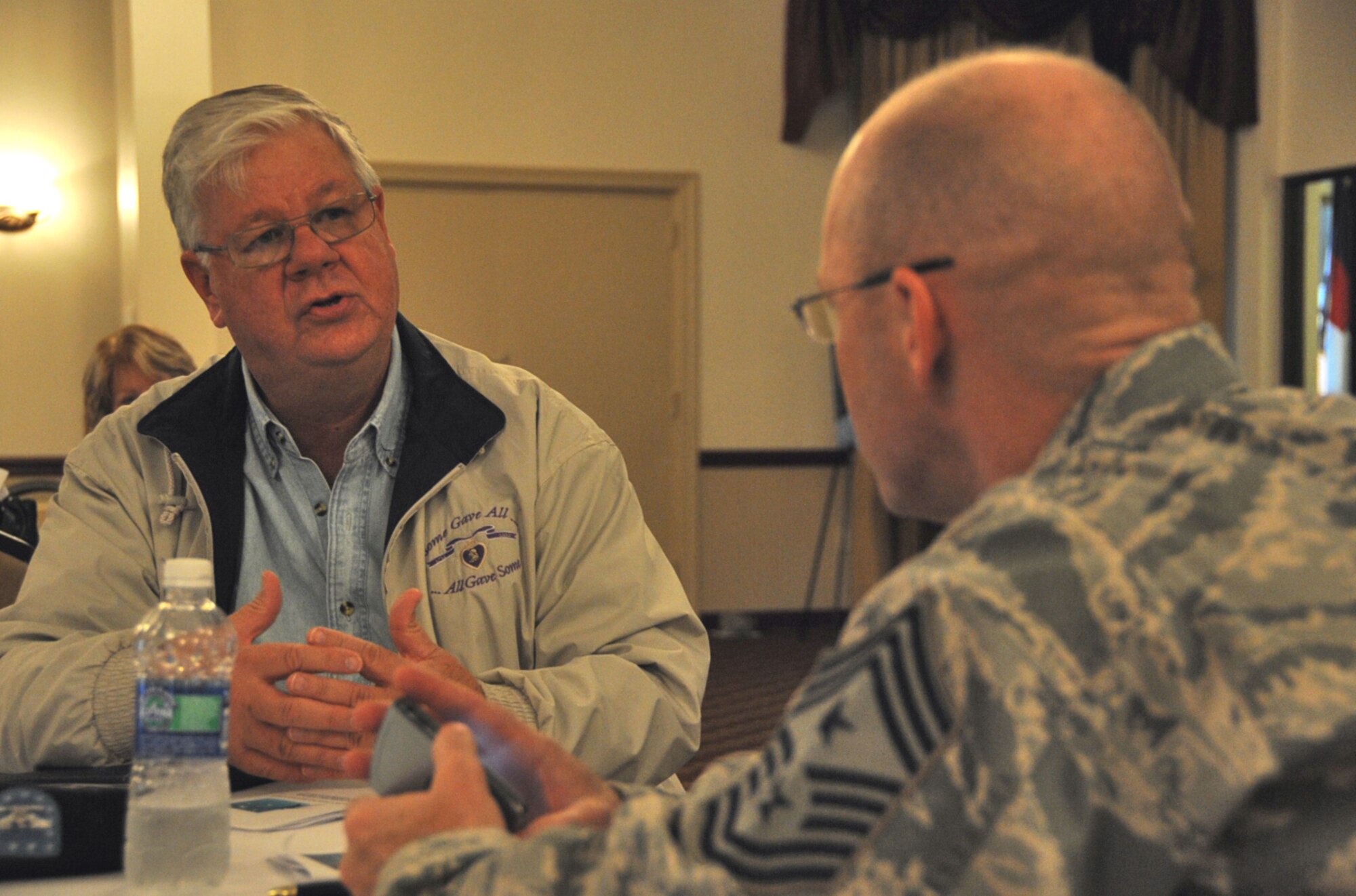Charles Byers Jr. speaks to Chief Master Sgt. Warren Wofford, 87th Air Base Wing command chief, during the National Disability Employment Awareness Month luncheon at the base community center Oct. 27. Byers, who was the guest speaker for this year’s event, is the recipient of a Silver Star, a Bronze Star with Valor and a Purple Heart for his service in the Army from 1966-1972. Currently, Byers is the president of South Jersey Vietnam Veterans Association. (U.S. Air Force photo/Senior Airman David Carbajal)
