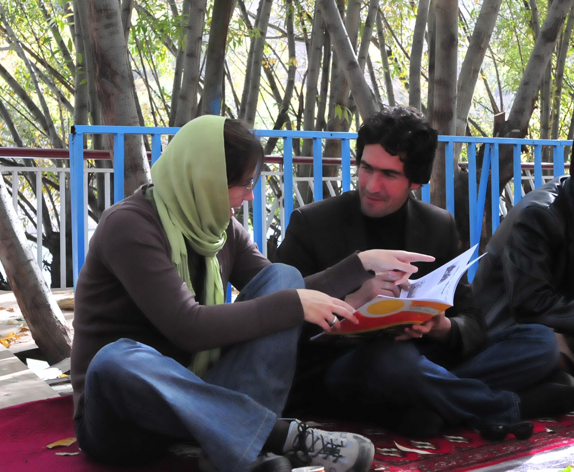 Fahim Fetrat, Roz Afghan News, shows Ana Pereira, representative from Portugal Publico Newspaper, a copy of SUN magazine during the conclusion of Panjshir PRT's media event. The magazine is the first woman's magazine published in Panjshir. Pereira said, "The day was a completely different experience with Afghans in the Afghan environment eating what they eat, sitting where they sit. It was a wonderful day and opportunity to see projects and meet people and see what their problems and expectations are." The media event provided the opportunity for the PRT to highlight the civilian and military partnership, its current activities and its efforts to promote a more effective Afghan government. (U.S. Air Force photo by: 2nd Lt. Ashleigh Peck, Panjshir PRT Public Affairs)