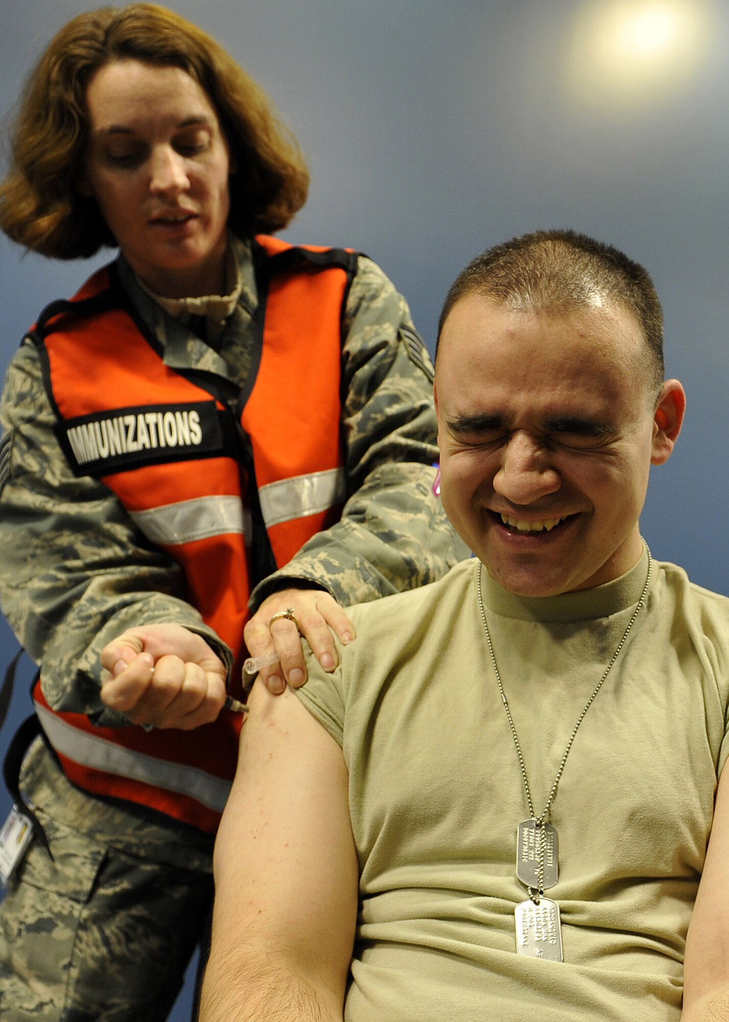 U.S. Air Force Staff Sgt. Rebecca Lozano, 35th Medical Operations Squadron allergy immunizations technician, administers a shot to U.S. Air Force Staff Sgt. Aaron Bogdanovic, 35th Comptroller Squadron, during the personnel deployment function portion of an operational readiness exercise, Nov. 5, 2010, at Misawa Air Base, Japan. The PDF is the final check for Airmen and ensures all their paperwork and medical records are complete before deploying. (U.S. Air Force photo by Staff Sgt. Chad C. Strohmeyer/Released)