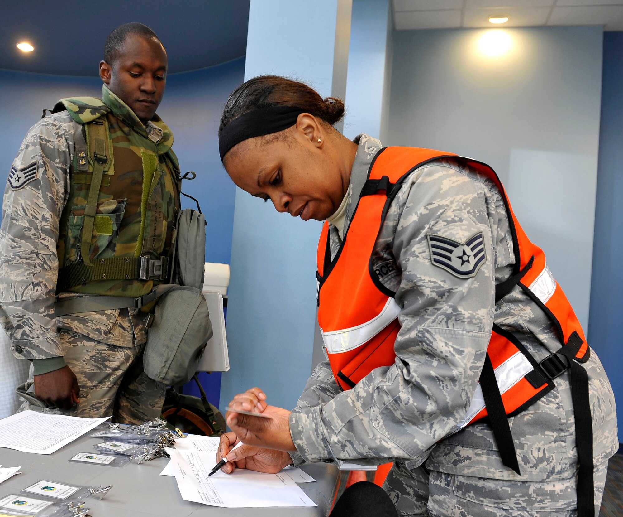 U.S. Air Force Staff Sgt. Colleen Thompson, 35th Force Support Squadron, checks identification during the personnel deployment function portion of an operational readiness exercise, Nov. 5, 2010, at Misawa Air Base, Japan. The PDF is the final check for Airmen and ensures all their paperwork and medical records are complete before deploying. (U.S. Air Force photo by Staff Sgt. Chad C. Strohmeyer/Released)