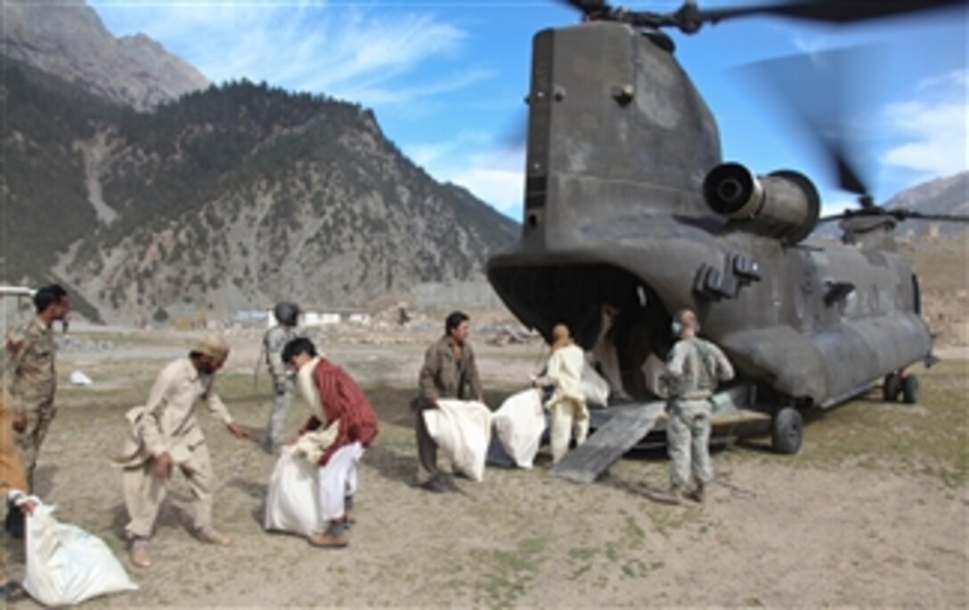Pakistanis unload relief supplies from a U.S. Army CH-47 Chinook helicopter assigned to the 16th Combat Aviation Brigade in Swat Valley, Pakistan, on Nov. 3, 2010.  