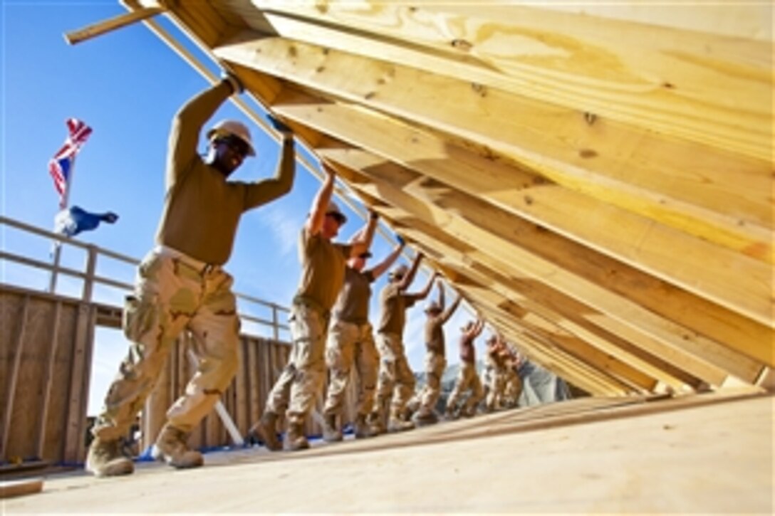 U.S. Navy Seabees erect an exterior wall for a Southwest Asian Hut on Kandahar Air Field, Afghanistan, Nov. 4, 2010. The Seabees are assigned to Naval Mobile Construction Battalion 18.