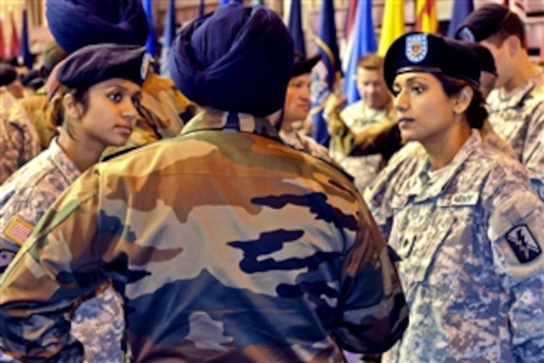 U.S. Army Cpl. Balreet Kaur and Spc. Jasleen Kaur, Indian-born sisters, compare common courtesies of the United States and India with an Indian soldier before the opening ceremony for the combined training exercise Yudh Abhyas on Joint Base Elmendorf-Richardson, Alaska, Oct 31. 2010. Balreet and Jasleen are California National Guardsmen assigned to the 79th Infantry Brigade Combat Team. Both are medics and cultural liaisons for the 14-day exercise.