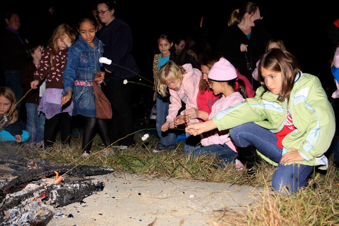 Iwakuni Girl Scout troops roast marshmallows around a bonfire Saturday evening to celebrate the birthday of Juliette Gordon Low, the founder of the USA Girl Scouts. To celebrate the outgoing nature and traditions of the USA Girl Scouts local troops sang songs, told stories and roasted hotdogs and marshmallows around the bonfire before camping out in tents during the night.