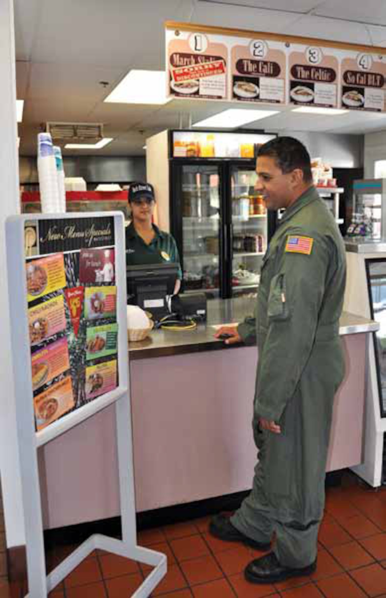 Master Sgt. Everett Bennett, 452nd Aero Medical Evacuation Squadron, looks at a menu board at the BackStreet Cafe. Oya Boyraz is at the cash register. (U.S. Air Force photo by Megan Just)
