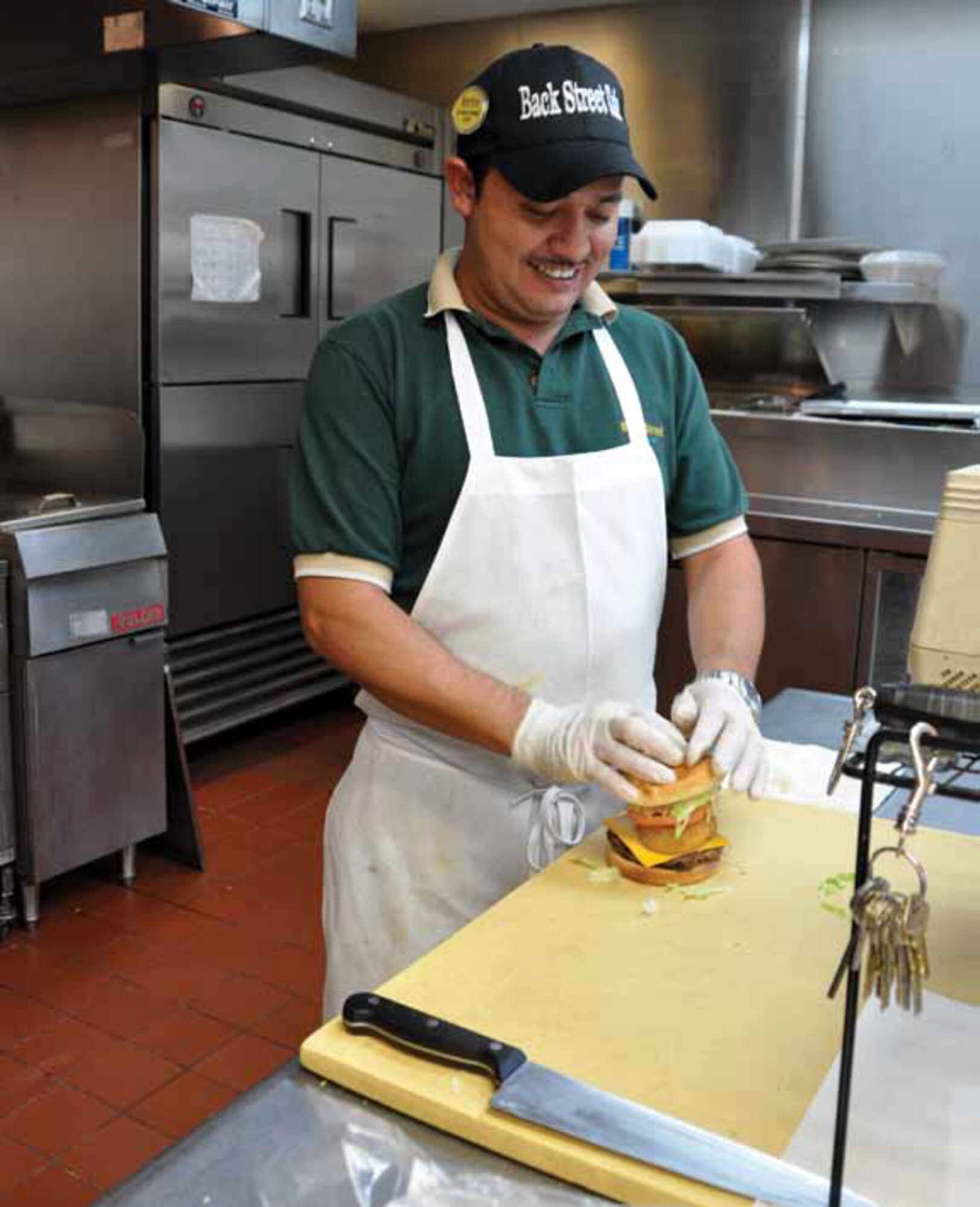Octavio Gomez prepares a gourmet hamburger at the Hap Arnold Club’s BackStreet Cafe. This month marks the BackStreet Cafe’s four-year anniversary. The cafe, along with other improvements, has helped to increase the club’s patronage. (U.S. Air Force photo by Megan Just)
