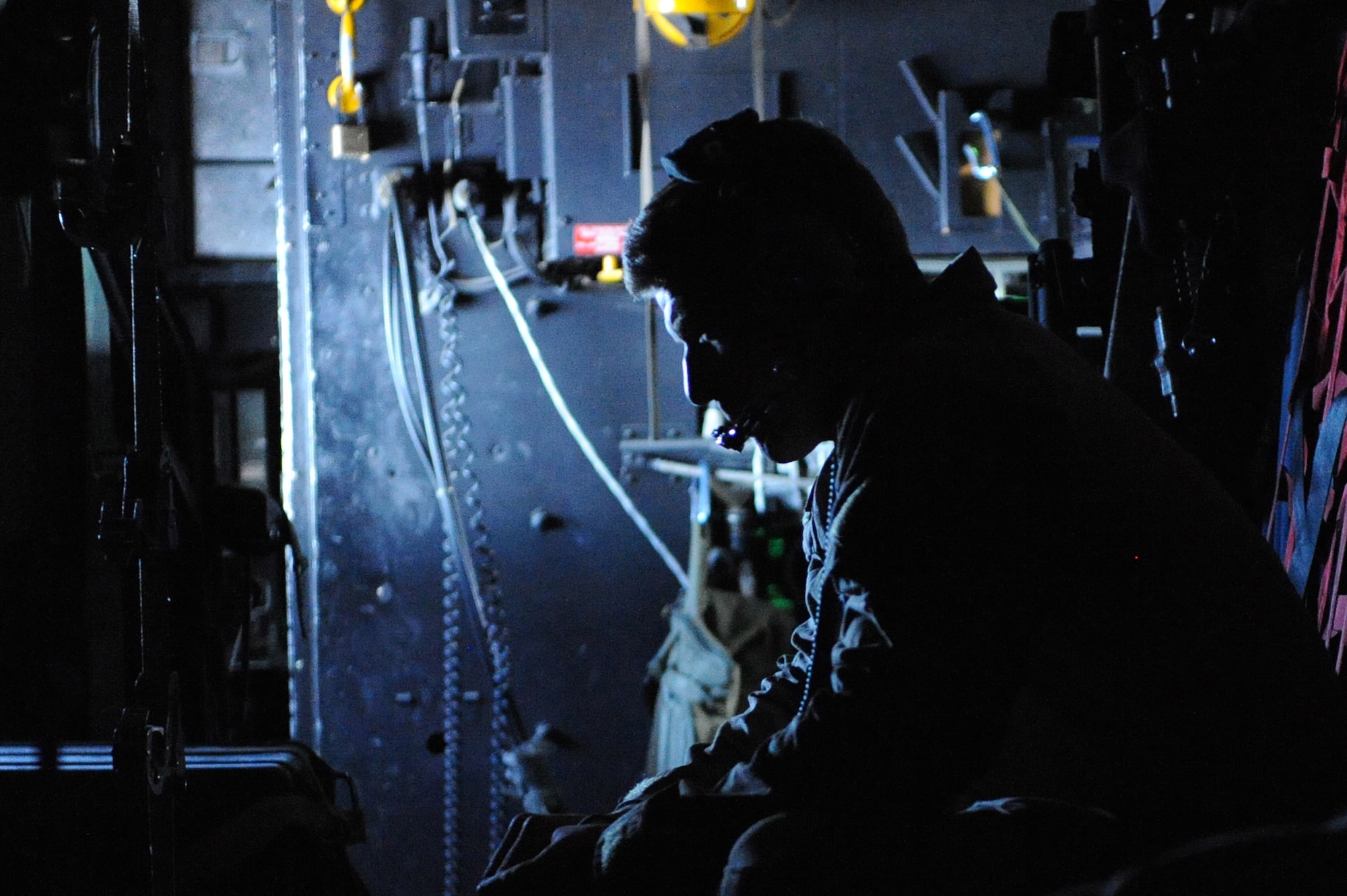 Staff Sgt. Christopher Freeman listens to the aircraft communications during a patient transfer on a C-130H Hercules over Afghanistan, November 2, 2010. Sergeant Freeman, deployed from the 38th Rescue Squadron at Moody Air Force Base, Ga., is a pararescueman with the 46th Expeditionary Rescue Squadron at Camp Bastion, Afghanistan. (U.S. Air Force photo/Tech. Sgt. Chad Chisholm)