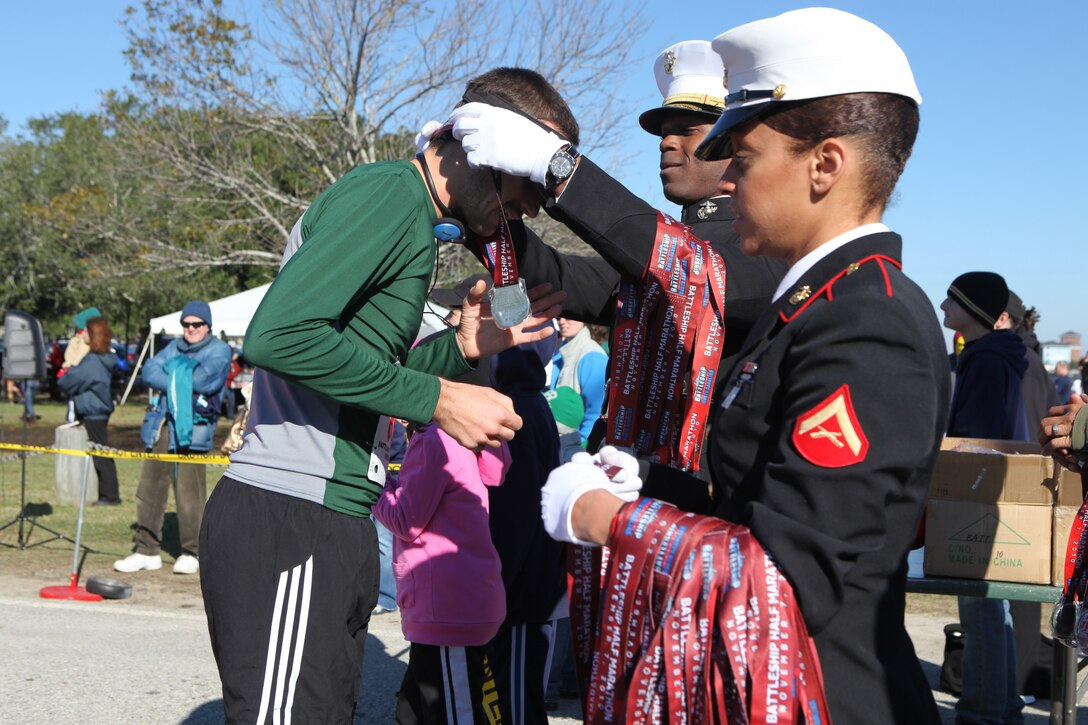 Marines award a medal to a runner after he finished the Carolina Sports Medicine’s 12th annual Battleship Half Marathon in Wilmington, N.C., Nov. 7.   The 13.1-mile race started and ended at the Battleship USS North Carolina and was dedicated to the men and women who have served and are currently serving in the United States Armed Forces.