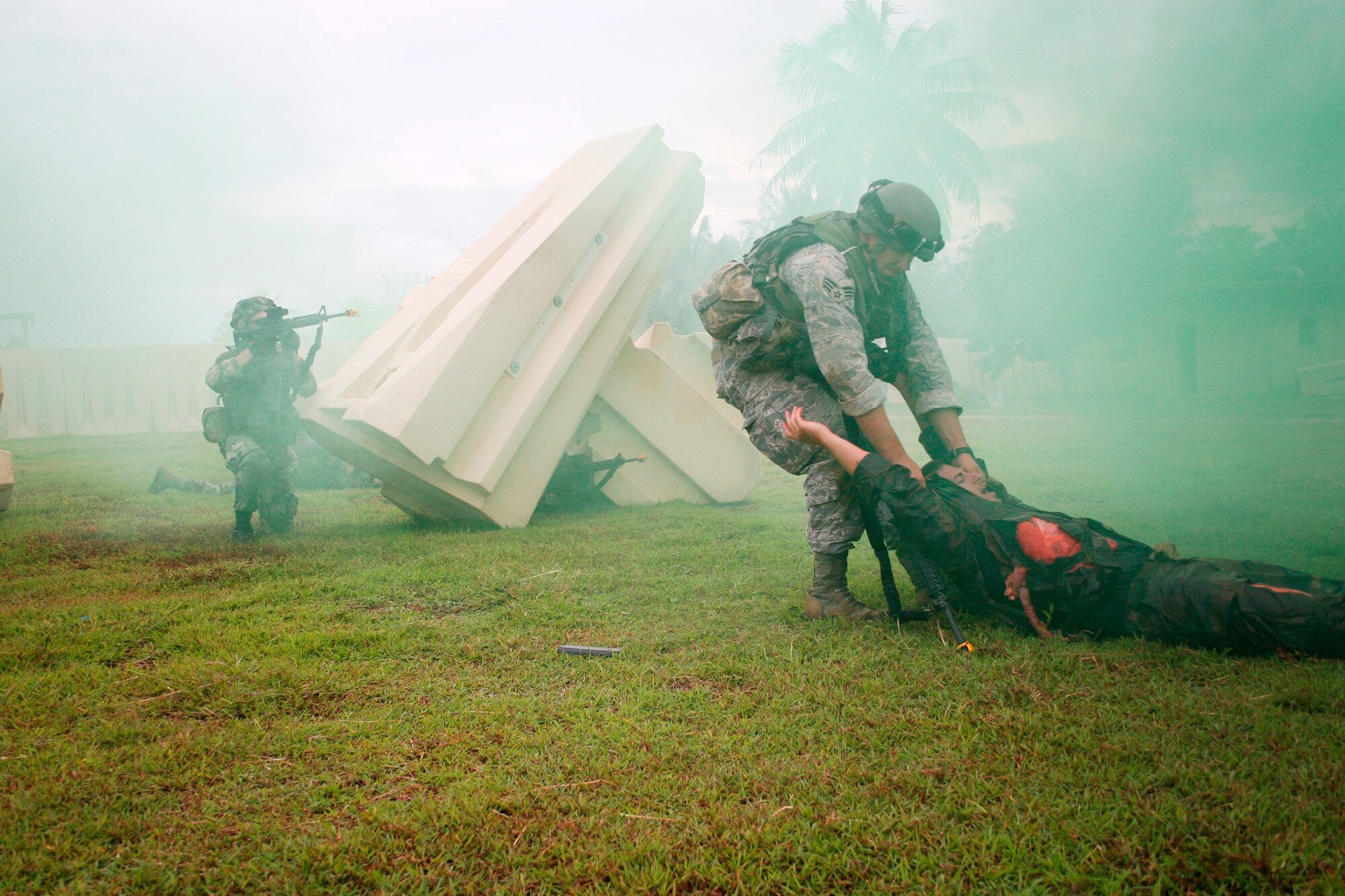 Senior Airman Joshua Moreland, 644th Combat Communications Squadron, drags a simulated wounded Stagg Sgt. Doug Kessler, 644 CBCS, to safety to perform Self Aid Buddy Care (SABC) while Tech. Sgt. Joshua Ward, also644 CBCS, and his fire team members provide cover fire during combat casualty training here during a 20-day Combat Readiness School (CRS) course recently. (Photo by Sara Mortimer)