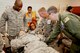 Majs. Huey McDaniel (far right), 403rd Aeromedical Staging Squadron flight surgeon, and John McKee, 403rd ASTS nurse, assess the condition of one of their 