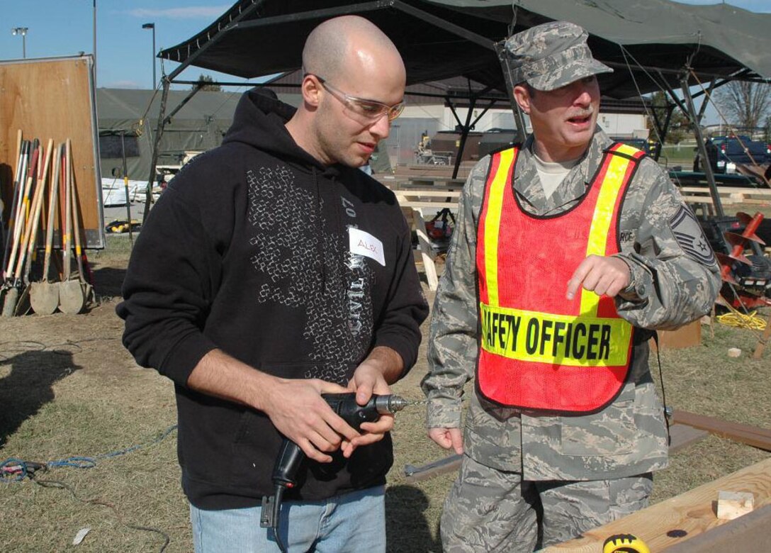 Senior Master Sgt. Kevin Green, 512th Airlift Wing safety NCO in charge, answers a question posed by a volunteer during the new park building project at Dover Air Force Base, Del., Nov. 6, 2010. The parked is slated for completion before the end of November and will be named after Dover AFB's Reserve unit, the Liberty Wing. (U.S. Air Force photo by Senior Airman Bhawan P. Singh/Released)