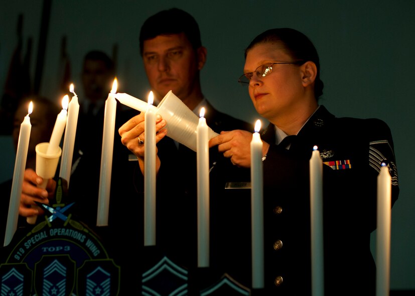 Master Sgt.s Tricia Miller and Lonney Melton light the ceremonial candles during the 919th Special Operations Wing senior NCO induction ceremony Nov. 6 at Duke Field.  The ceremony also inducted new staff sergeants within the wing.  46 staff sergeants and 30 master sergeants were inducted. (Air Force photo/Tech Sgt. Samuel King Jr.)