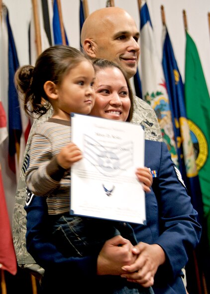 A new 919th Special Operations Wing NCO poses for a photo with her daughter during the NCO and senior NCO induction ceremony at Duke Field, Nov. 6.  46 staff sergeants and 30 master sergeants were inducted. (Air Force photo/Tech Sgt. Samuel King Jr.)