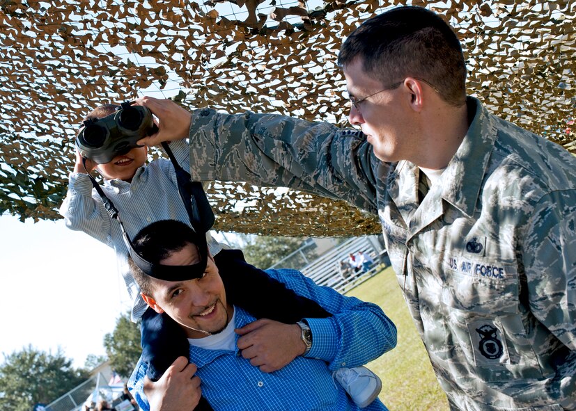 A father and son team test out the high tech binoculars of the 919th Security Forces Squadron at the 919th Special Operations Wing “family day” event at Duke Field, Nov. 6.   The Family Day event brought reservists and their families together for food, games and music. (Air Force photo/Tech. Sgt. Samuel King Jr.)