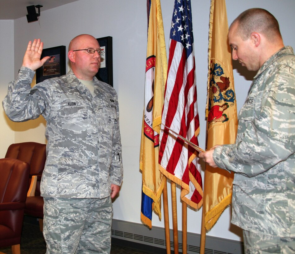 2nd Lt. Robert Mendez, a 108th Civil Engineer officer, administers the re-enlistment oath to Tech. Sgt. Michael Klein, an intelligence analyst with the 204th Intelligence Squadron on Nov. 6.  Klein re-enlisted four more years with the 108th Wing.  U.S. Air Force photo by Staff Sgt. Armando Vasquez, 108th Wing Public Affairs Office.