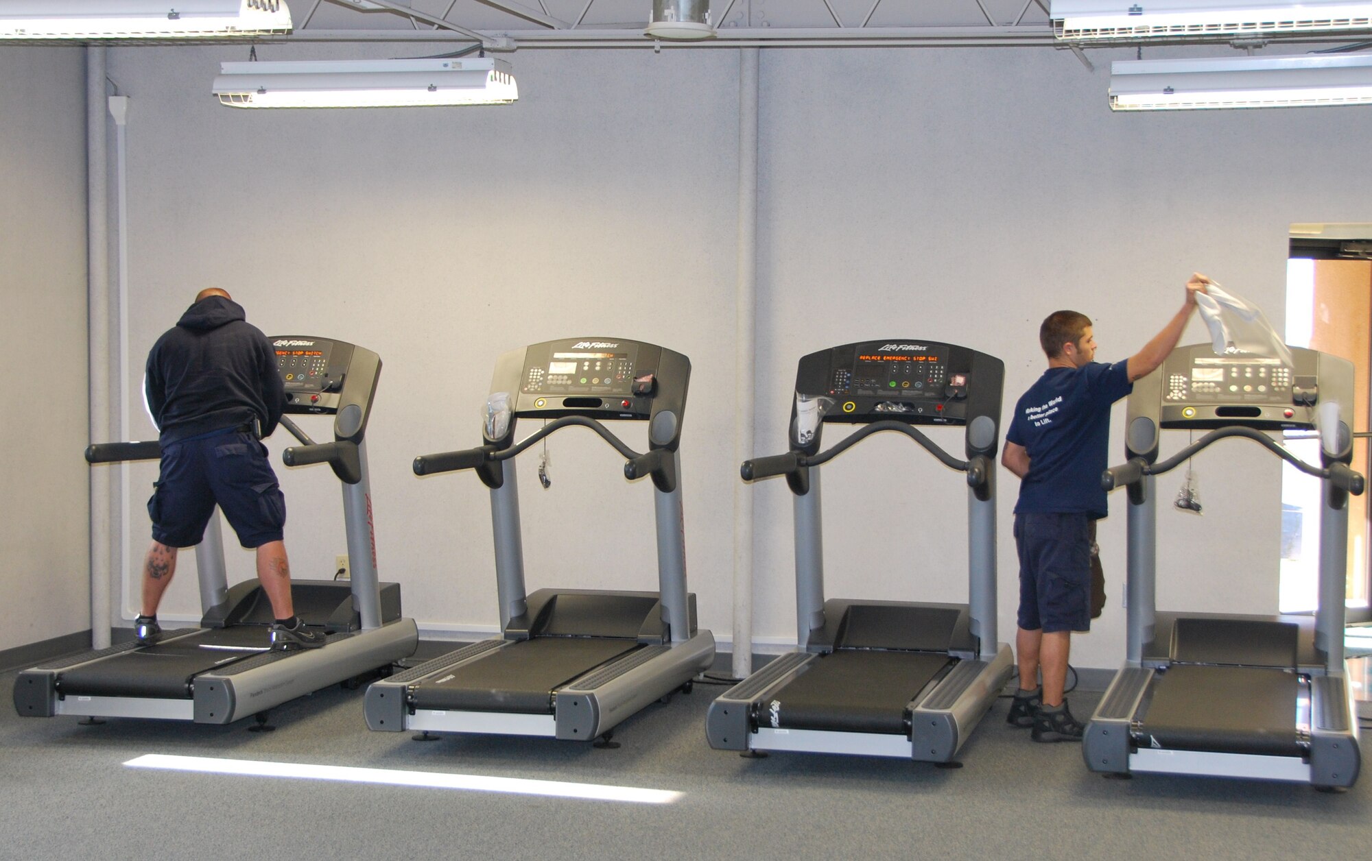 Civilian workers install and adjust four new treadmills in the space where the boxing equipment once stood on Oct. 29, 2010. The 507th Air Refueling Wing officially took over operation and management of the Tinker Fitness Center West on Oct. 1, 2010. (U.S. Air Force photo by Tech. Sgt. Zach Jacobs)
