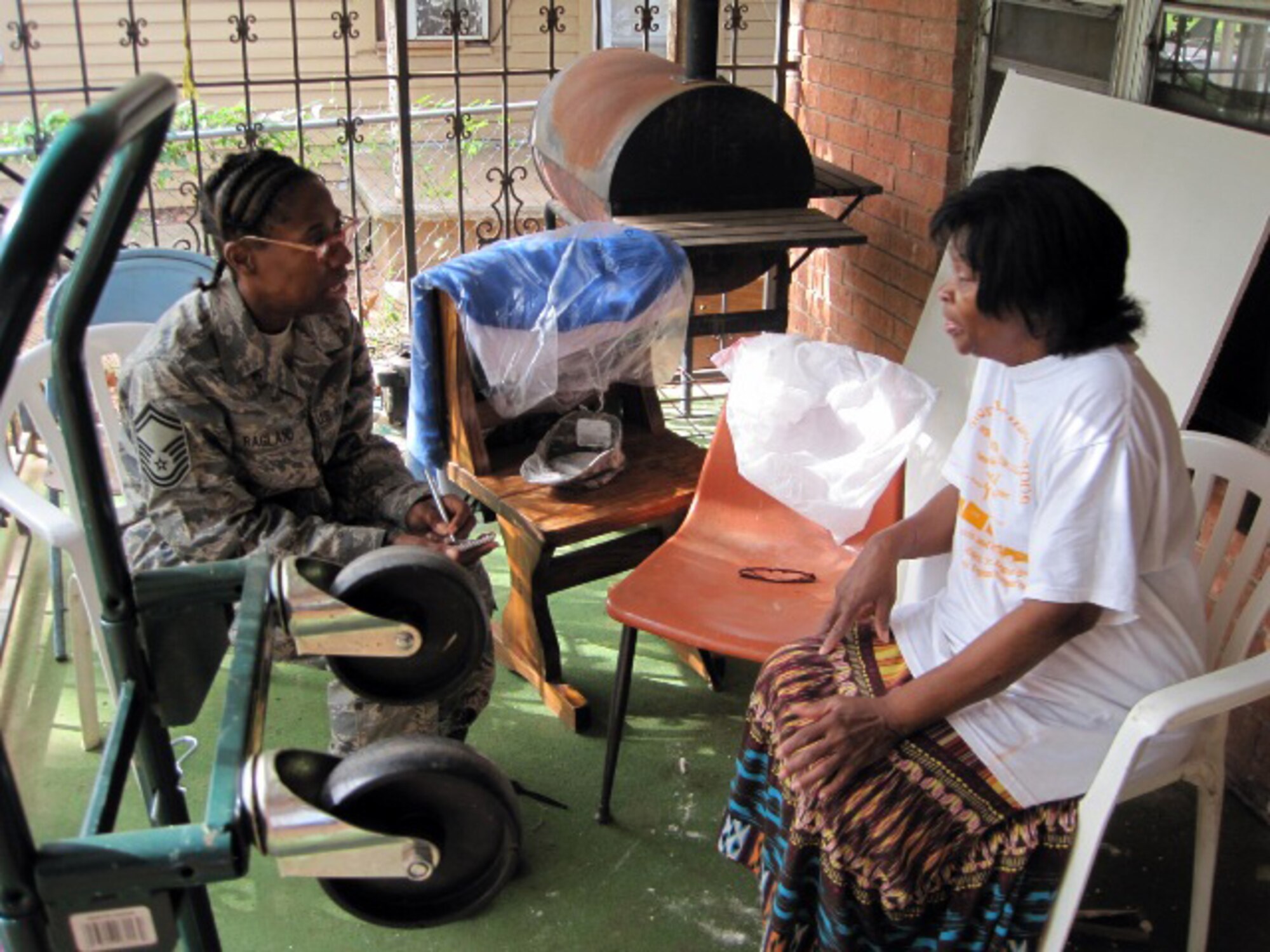 Senior Master Sgt. Treva Ragland talks to Ms. Treva Clark about her home and the problems Clark has endured.  Clark was recently named the winner of a home repair project from the Rebuilding Together charity and franchisees and associates of Choice Hotels' Econo Lodge and Rodeway Inn brands.  (U.S. Air Force photo)