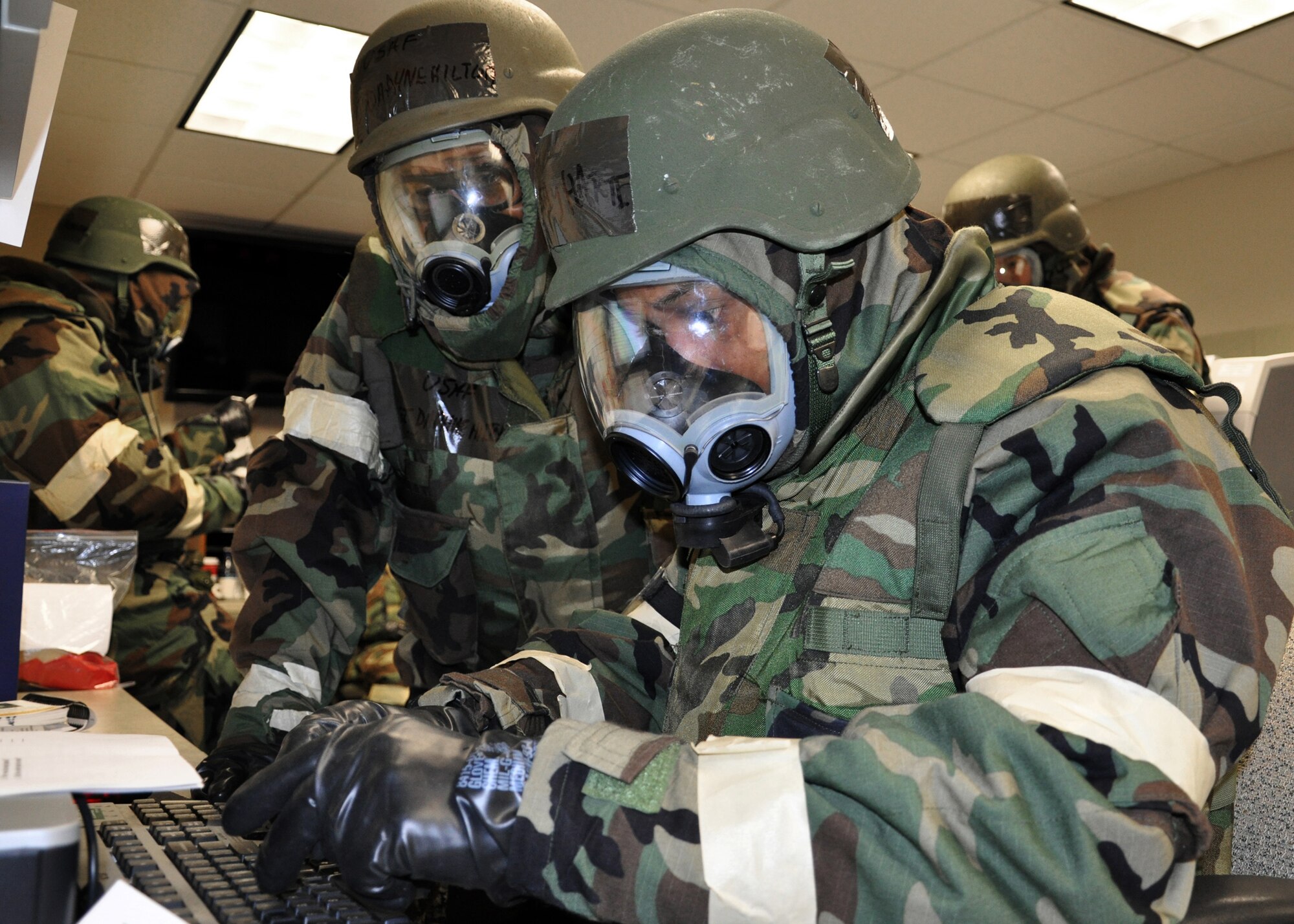 JOINT BASE MCGUIRE-DIX-LAKEHURST, N.J. ? Technical Sgt. Daphne Hilton (left) observes while Tech. Sgt. Lindsay Harte works on her computer during a mobility exercise here Nov. 6, 2010. Both Airmen, who are from the 514th Aeromedical Evacuation Squadron, are wearing their chemical protective over-garment in mission-oriented protective-posture (MOPP) 4. (U.S. Air Force photo/Tech. Sgt. Shawn J. Jones)