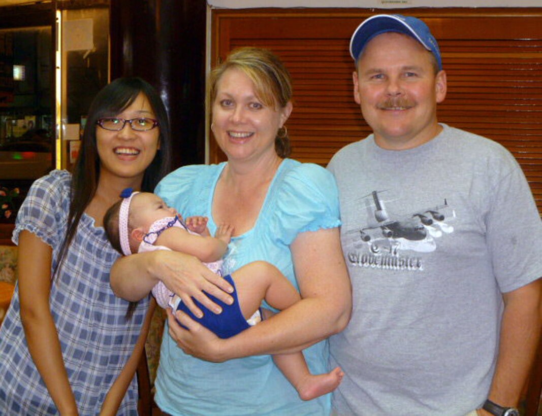 Senior Master Sgt. Lance Gustafson and his wife Denice, center, celebrate the adoption of their new daughter, Abi, with their interpreter during the final stage of the process in Taiwan earlier this year.  This is the second adoption for Sergeant Gustafson, a loadmaster superintendent with the 313th Airlift Squadron.  He and Denice adopted a girl from Kazakhstan four years ago.  They also have three biological children.  "Kids bring a lot of joy to your life," said Sergeant Gustafson. (courtesy photo/Senior Master Sgt. Lance Gustafson)