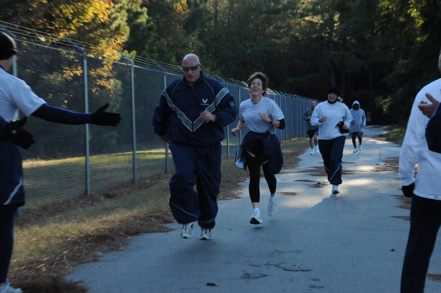 Chief Tim Erdmann, Maintenance Group, crosses the finish line with Col. Caroline Evernham, Operations Group, close on his heels during the 916th's Semi-Annual Warrior Run. (USAF photo by MSgt. Gillian Albro, 916FSS)