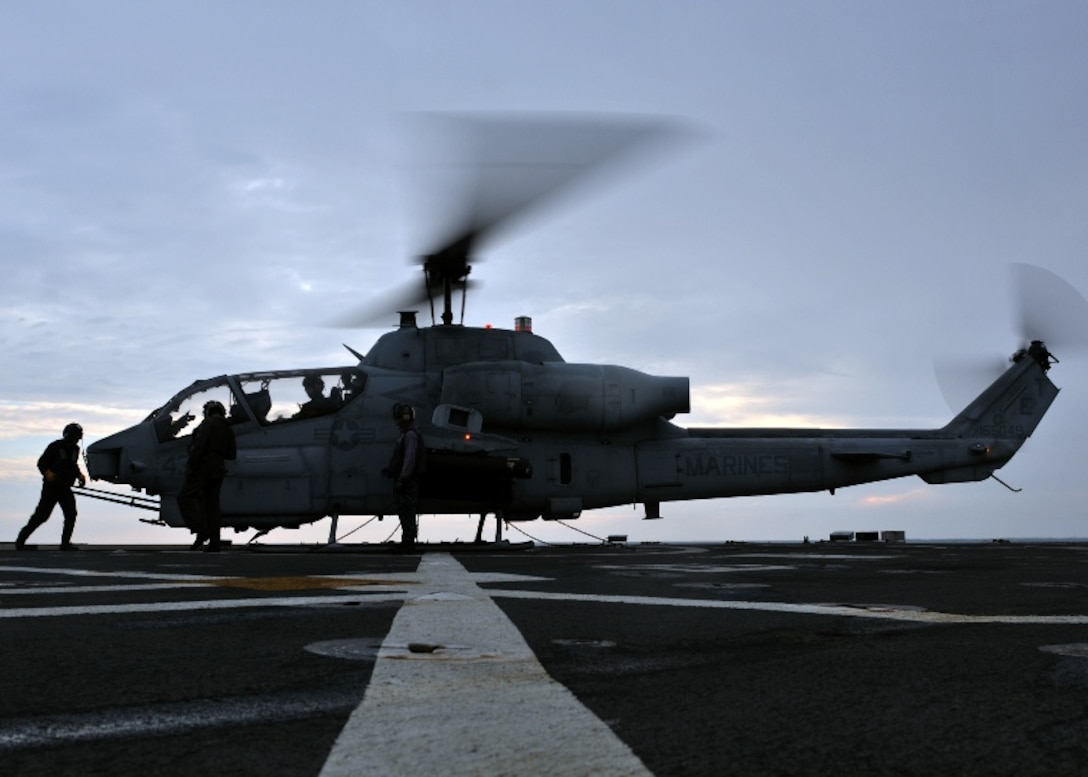 Air department Sailors stand by to remove the chock and chain gear from an AH-1 Cobra helicopter as the pilot prepares to board the helicopter during deck landing qualifications (DLQ) aboard the flight deck of the amphibious transport dock USS Denver (LPD 9). Denver is part of the permanently forward-deployed Essex Amphibious Ready Group and is underway for a scheduled patrol in the Western Pacific ocean.