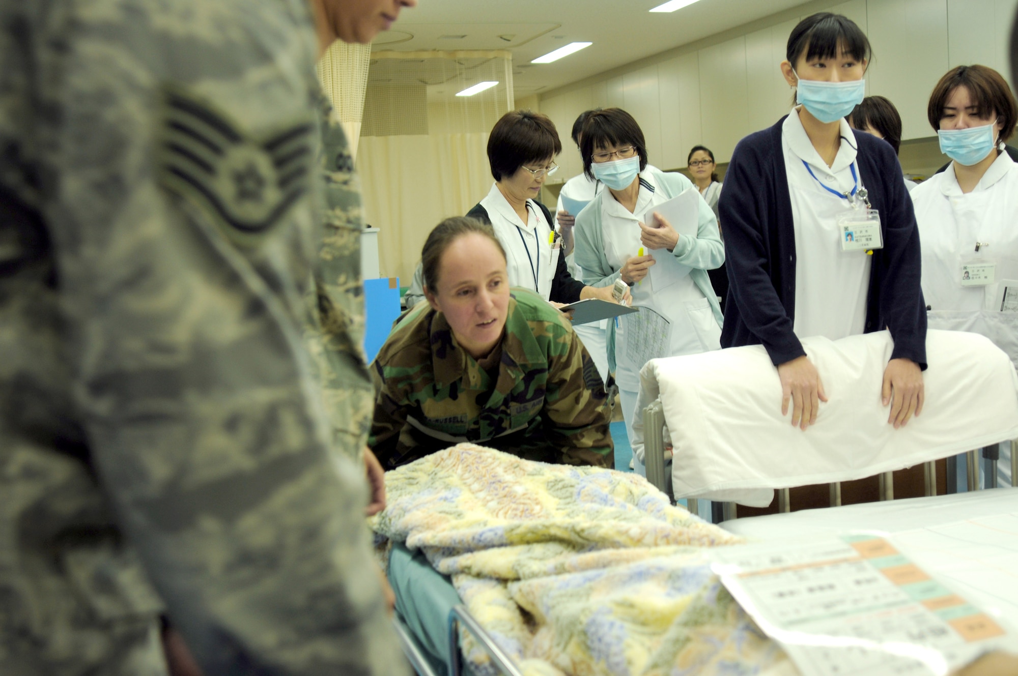 A 35th Medical Group Airman prepares to move a patient from stretcher to bed Nov. 5, 2010, at the new Misawa City Hospital. Misawa officials opened the new hospital last week and requested military assistance in transporting patients from the old hospital to the new building. More than 20 service members from Naval Air Facility Misawa and the 35th Medical Group assisted with the transfer. U.S. Navy photo by Mass Communication Specialist 2nd Class Matthew M. Bradley