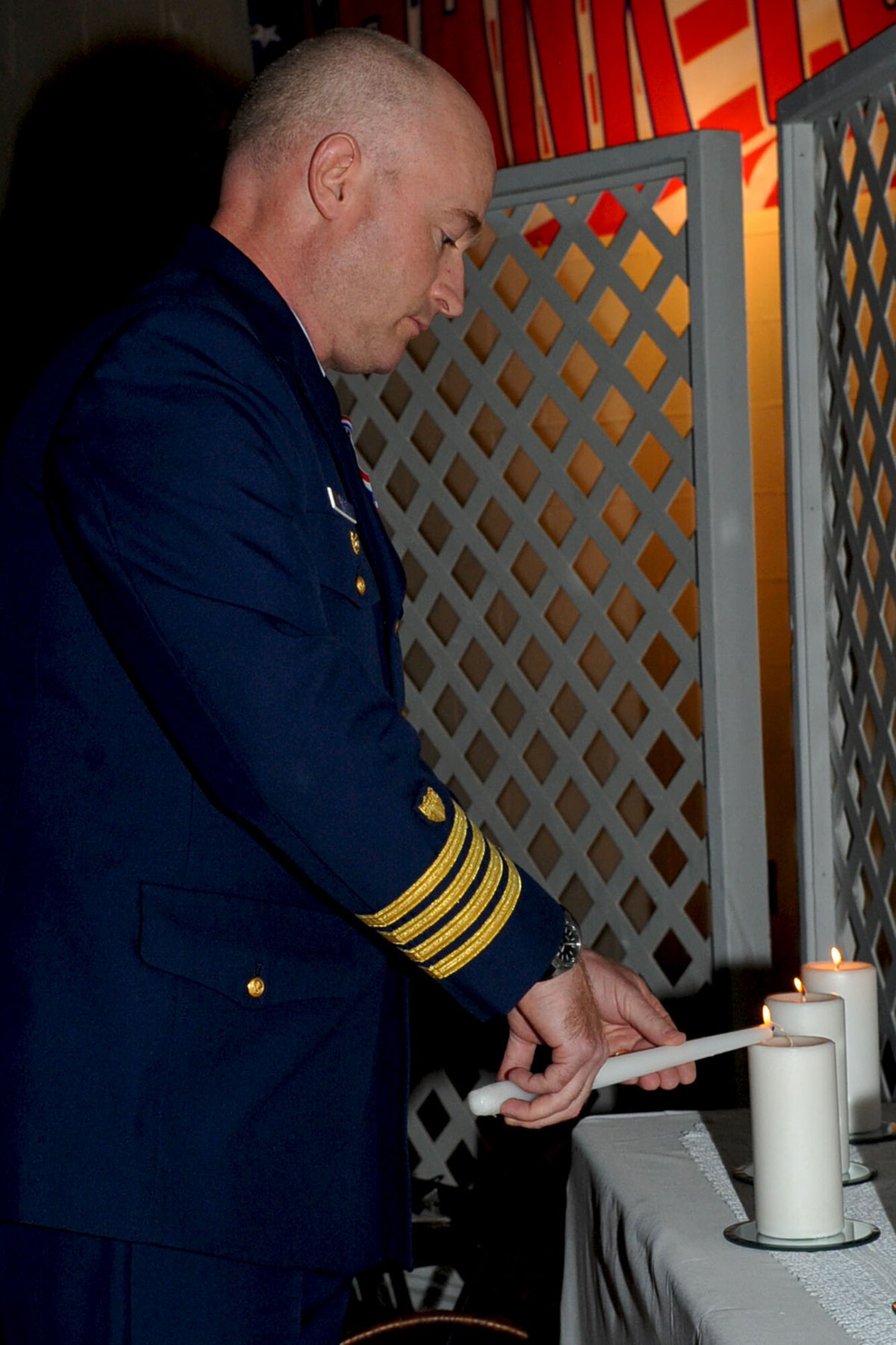 CHESAPEAKE, Va. -- U.S. Coast Guard Capt. Sean Mahoney, lights a candle for his branch of service during the Veteran's Day ceremony Nov. 4. The Niners Citizen's Club hosted the event at the South Norfolk Community Recreation Center to honor all active-duty and retired military.(U.S. Air Force photo/Staff Sgt. Ashley Hawkins)(RELEASED)