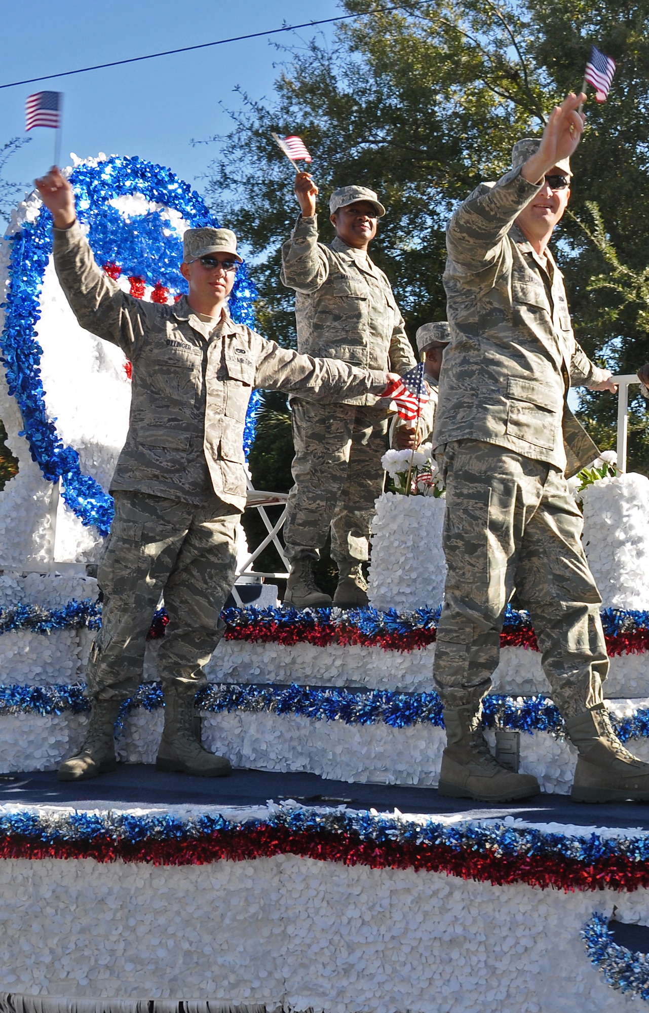 Airman 1st Class Jeremy Ottinger (left), Chief Master Sgt. Gigi Manning, command chief master sergeant of the 315th Airlift Wing (center), and Maj. Paul Jacquet wave to spectators 315th AW float during the Charleston, SC Veterans Day Parade November 7, 2010. About 80 Reservists volunteered their time to participate in the parade honoring those who serve and have served in our nation's military. (U.S. Air Force Photo/Senior Airman Dani Shea)