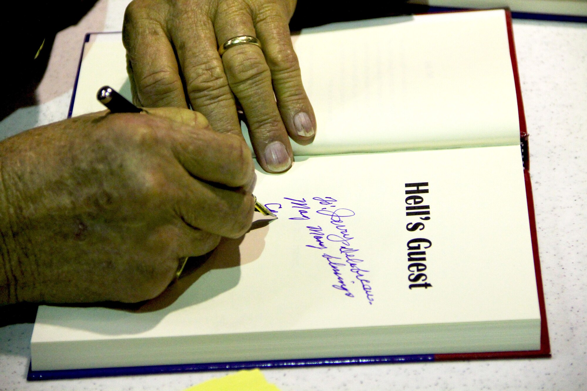 PATRICK AIR FORCE BASE, Fla. ? Colonel Glenn Frazier, author of ?Hell?s Guest,? signs his book for the Rescue Reservists of the 920th Rescue Wing here. Thirty airmen were present for Colonel Frazier?s oration. Colonel Frazier talks about his experience as a Prisoner of War survivor during the grueling Bataan Death March that started April 9, 1942 in his book. He sits daily at the USS Alabama, a decommissioned U.S. Navy ship, now a museum, in Mobile Bay, Ala., and signs books and speaks with tourists. (U.S. Air Force photo/Staff Sgt. Leslie Kraushaar)