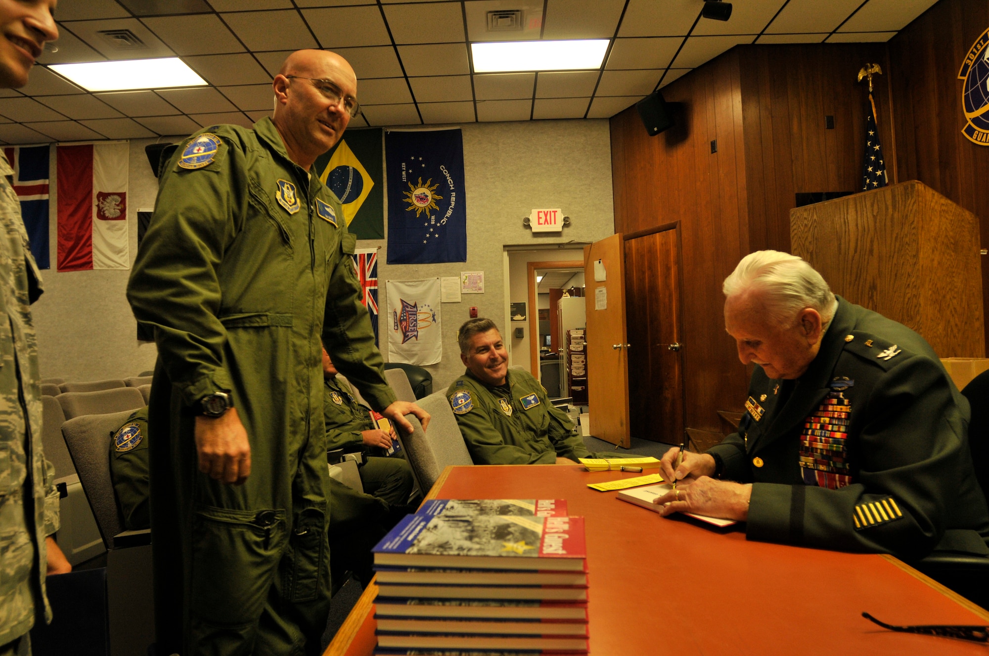 PATRICK AIR FORCE BASE, Fla. ? Colonel Glenn Frazier (Ret.), an American Prisoner of War and Bataan Death March survivor from April 9, 1942 to Sept. 4, 1945, signs a book for Lt. Col. Tim Davis, a rescue reserve helicopter pilot with the 920th Rescue Wing. Colonel Frazier spent one-on-one time with the helicopter pilots and crew before speaking to the wing during the drill weekend, November 6, 2010.  The Bataan Death March was a forced, brutal march of about 80,000 American and Filipino prisoners at the beginning of WWII. Out of the 80,000 prisoners only about 54,000 made it to the final camp, Camp O?Donnell.  (U.S. Air Force photo/Staff Sgt. Leslie Kraushaar)