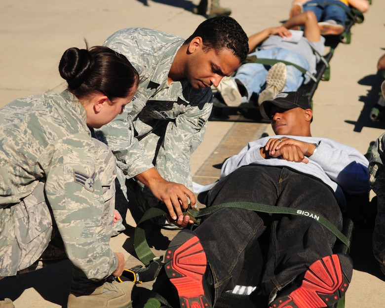 DAVIS-MONTHAN AIR FORCE BASE, Ariz. - Airmen from the 355th Medical Group secure a mock patient to a gurney prior to transporting him to a triage area for initial medical assessments as part of a National Disaster Medical Systems Exercise on the Snowbird ramp here Nov. 4. Airmen from the 355th MDG and civilian medical personnel from various agencies in Tucson participated in the NDMSE, which is designed to test the ability of military and civilian medical groups to work together to receive casualties, provide triage, and transport patients to area hospitals. (U.S. Air Force photo/Airman 1st Class Jerilyn Quintanilla)