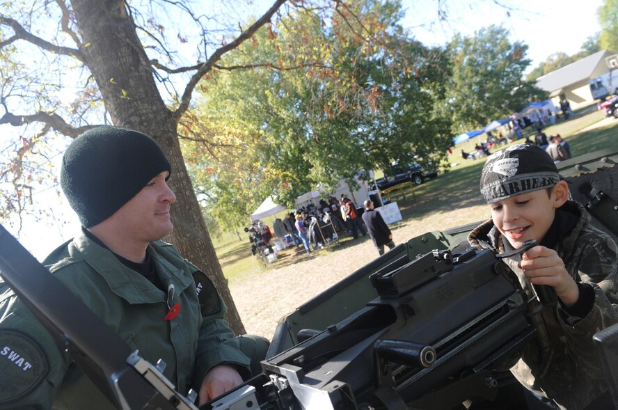 Tech. Sgt. Andrew Hallead, 2nd Security Forces Squadron, demonstrates a Mark 19, automatic grenade launcher to Christian Giddens, 9, son of Chad Giddens of Shreveport, La. The 2 SFS brought two humvees to the Vets for Vets bike rally in  Shreveport Nov. 6 as a static display.  (U.S. Air Force photo/Senior Airman Alexandra M. Boutte) (RELEASED) 
