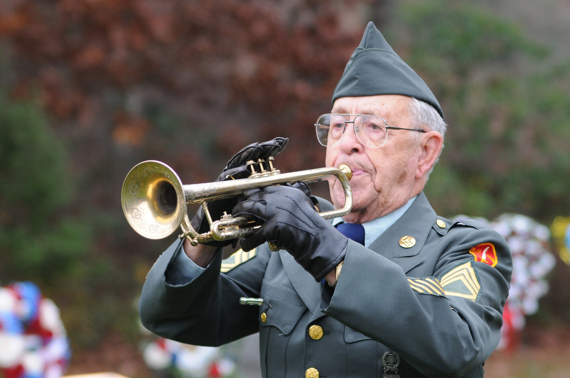 On November 7, 2010, a Veterans Day ceremony was held at the Massachusetts National Cemetery in Bourne, Mass., to remember veterans of the United States military. In this photo Mr. Albert J. Madden, Sergeant First Class, US Army (RET) and US Navy Veteran of World War II, play TAPS on his trumpet during the somber ceremony that marked the 91st anniversary of Veterans Day.