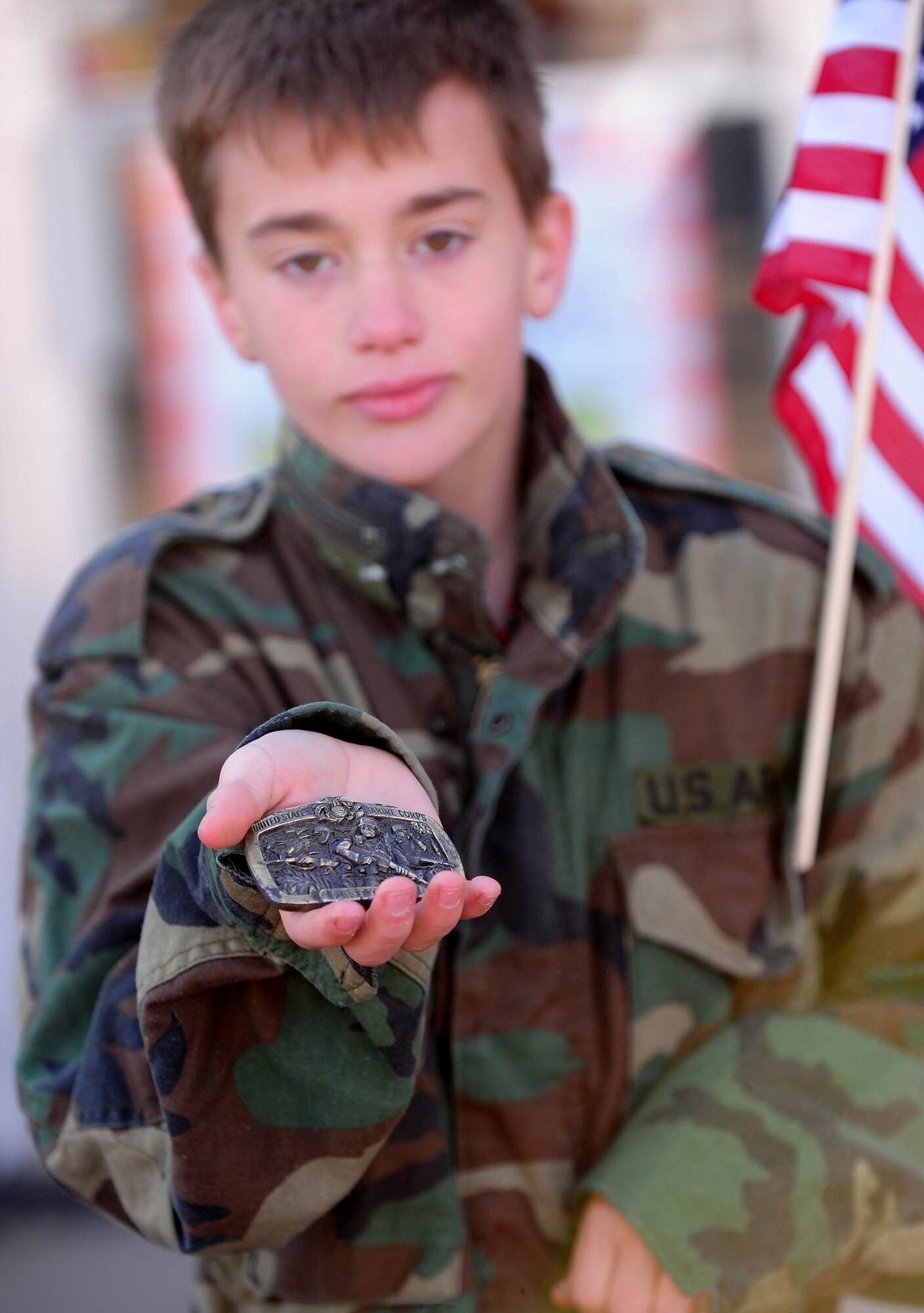 OFFUTT AIR FORCE BASE, Neb. -- Grant Fainter, a 12-year-old Bellevue, Neb., resident, proudly shows off his grandfather's Marine Corps belt buckle as he honors America's veterans during Nebraska's Official Veterans Parade, Nov. 6 in Olde Towne Bellevue.  The annual parade showcased more than 400 Team Offutt troops with the 55th Wing, Air Force Weather Agency, U.S. Strategic Command and Heartland of America Band. U.S. Air Force photo by Josh Plueger (Released)
