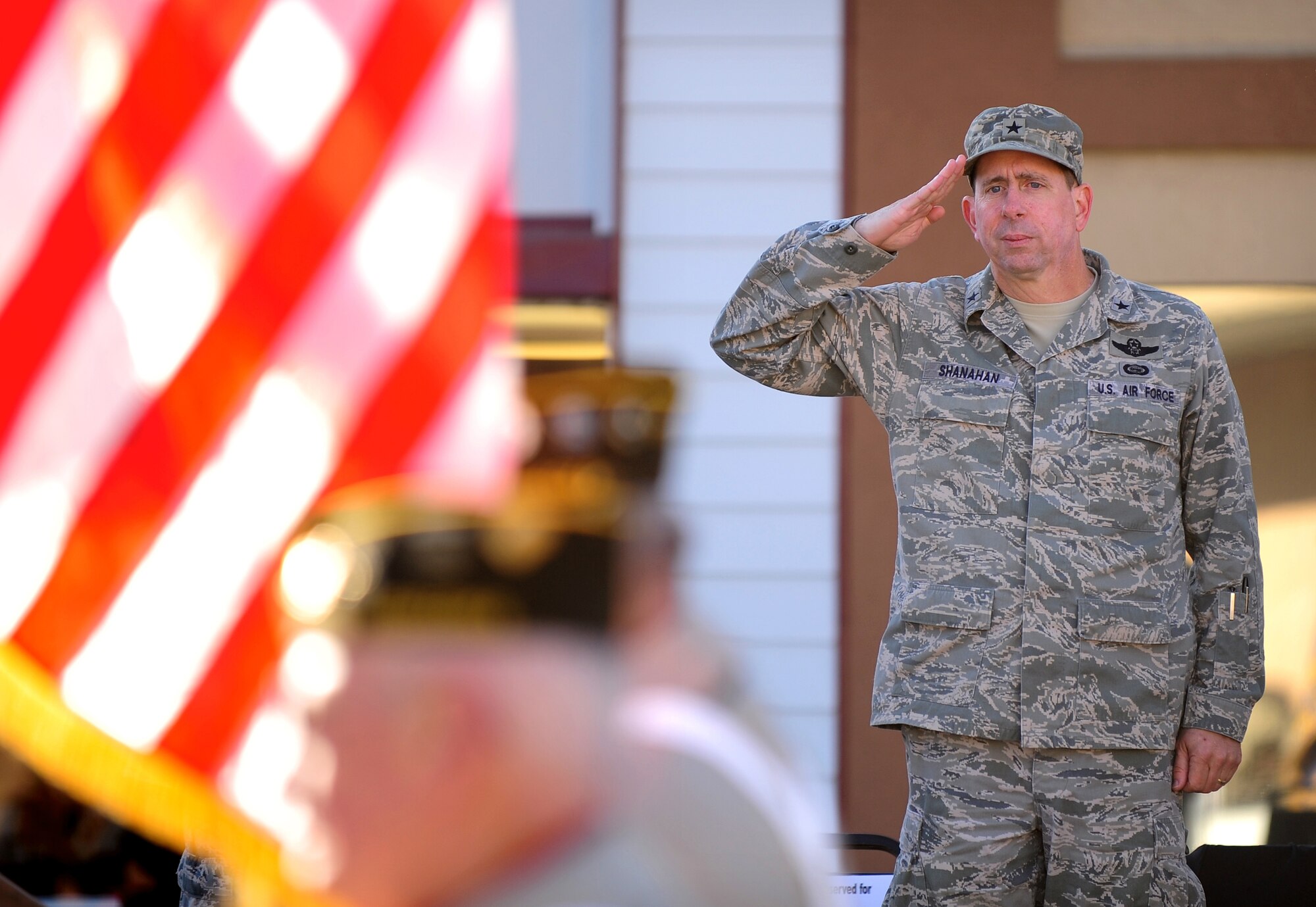 OFFUTT AIR FORCE BASE, Neb. -- Brig. Gen. John N.T. Shanahan, 55th Wing commander, salutes an American Flag carried by veterans as is passes down Mission Avenue, Old Town Bellevue, during Nebraska's Official Veterans Parade, Nov. 6.  The annual parade showcased more than 400 troops from Team Offutt including the 55th Wing, Air Force Weather Agency, U.S. Strategic Command and Heartland of America Band.  U.S. Air Force photo by Josh Plueger (Released)
