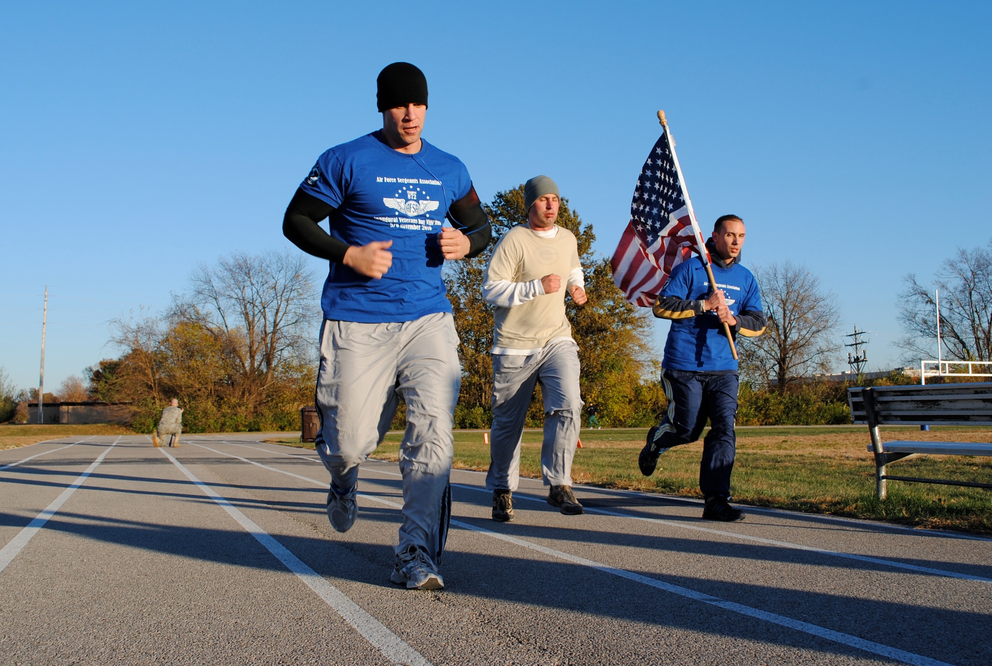 Tech. Sgts. Matthew Spatz, Richard Corey and Charles Conley keep the flag moving during the first laps of the Air Force Sergeants Association Veterans Day Vigil Run at the James Gym track Nov. 5 at Scott Air Force Base, Ill.  During the 24-hour relay style run a flag was carried continuously around the track and a vigil candle remained alight in honor of veterans past and present.  The run began at 5 p.m. Nov. 5 and ended at 5 p.m. Nov. 6. (U.S. Air Force Photo by Bekah Clark)