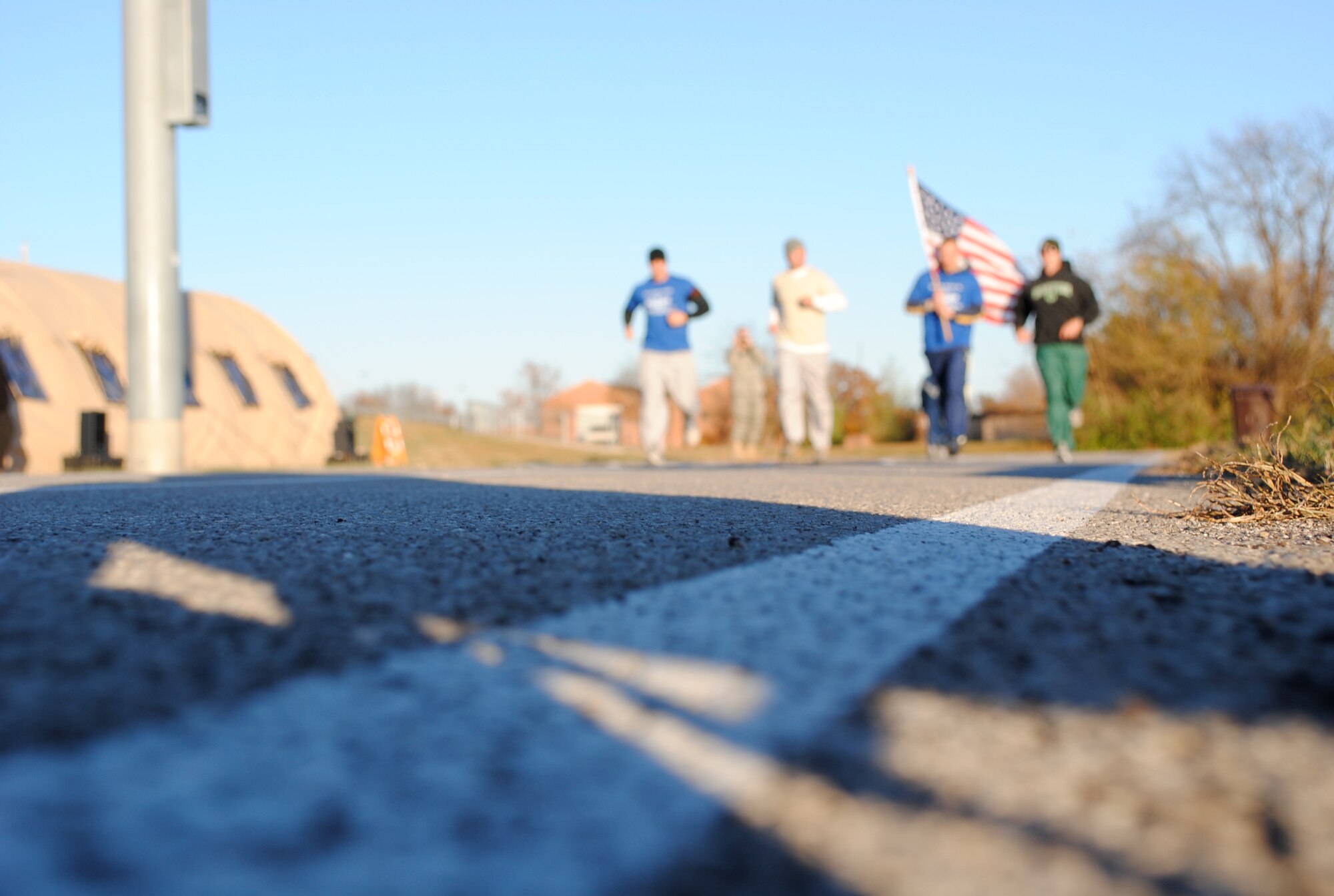 Tech. Sgts. Matthew Spatz, Richard Corey and Charles Conley and Staff Sgt. Adam Foye keep the flag moving during the first laps of the Air Force Sergeants Association Veterans Day Vigil Run at the James Gym track Nov. 5 at Scott Air Force Base, Ill.  During the 24-hour relay style run a flag was carried continuously around the track and a vigil candle remained alight in honor of veterans past and present.  The run began at 5 p.m. Nov. 5 and ended at 5 p.m. Nov. 6. (U.S. Air Force Photo by Bekah Clark)