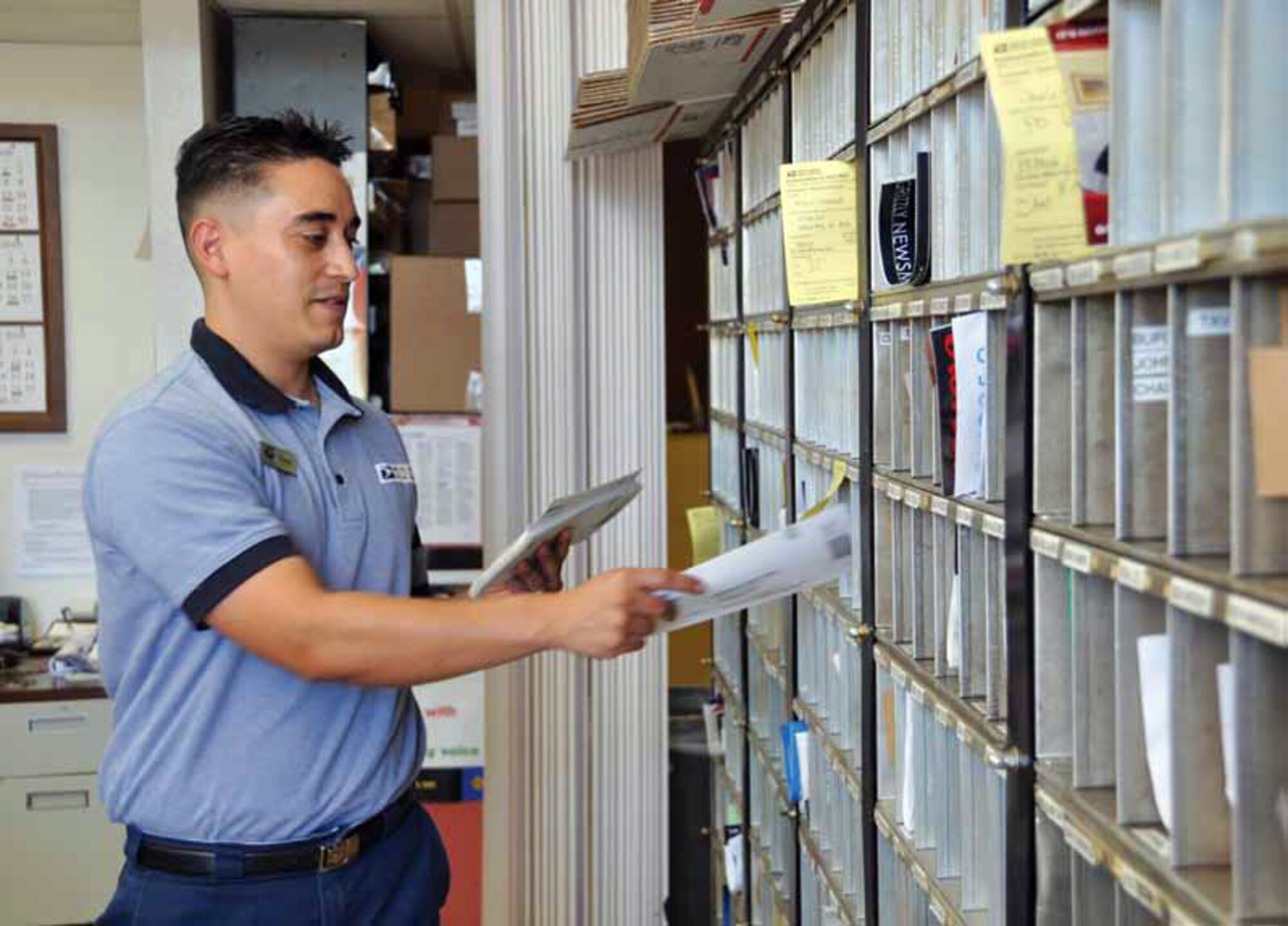 Frank Saucedo, sales service associate at the March Field Post Office, delivers mail to base post office boxes Nov. 1. Deadlines for mailing holiday packages to servicemembers overseas are quickly approaching.  (U.S. Air Force photo by Linda Welz)
