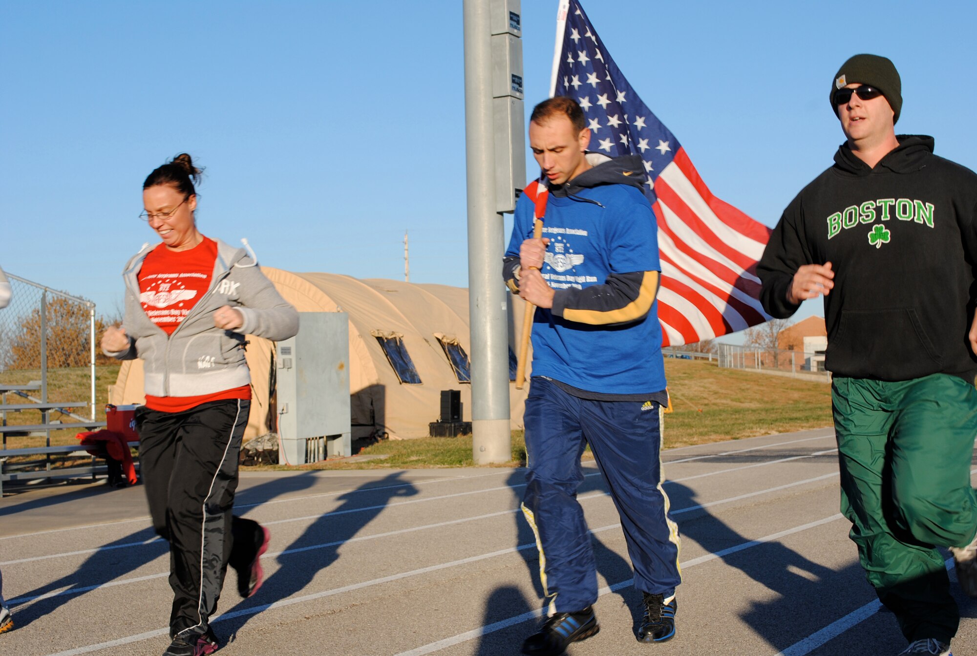 Staff Sgt. Alison Caldieraro, Tech. Sgt. Charles Conley, and Staff Sgt. Adam Foye, all of the 375th Logistics Readiness Squadron, finish the first lap at the James Gym track during the Nov. 5 at Scott Air Force Base, Ill.  During the 24-hour relay style run a flag was carried continuously around the track and a vigil candle remained alight in honor of veterans past and present.  The run began at 5 p.m. Nov. 5 and ended at 5 p.m. Nov. 6. (U.S. Air Force Photo by Bekah Clark)