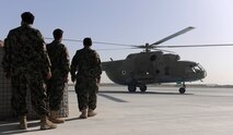 KANDAHAR AIRFIELD, Afghanistan -- Members of the Afghanistan National Army Air Force’s 305th Aircraft Maintenance Squadron approach a Russian MI-17 helicopter to arm it with 57 millimeter rockets before flying an escort mission Oct. 20. (U.S. Air Force photo/Senior Airman John Strong)